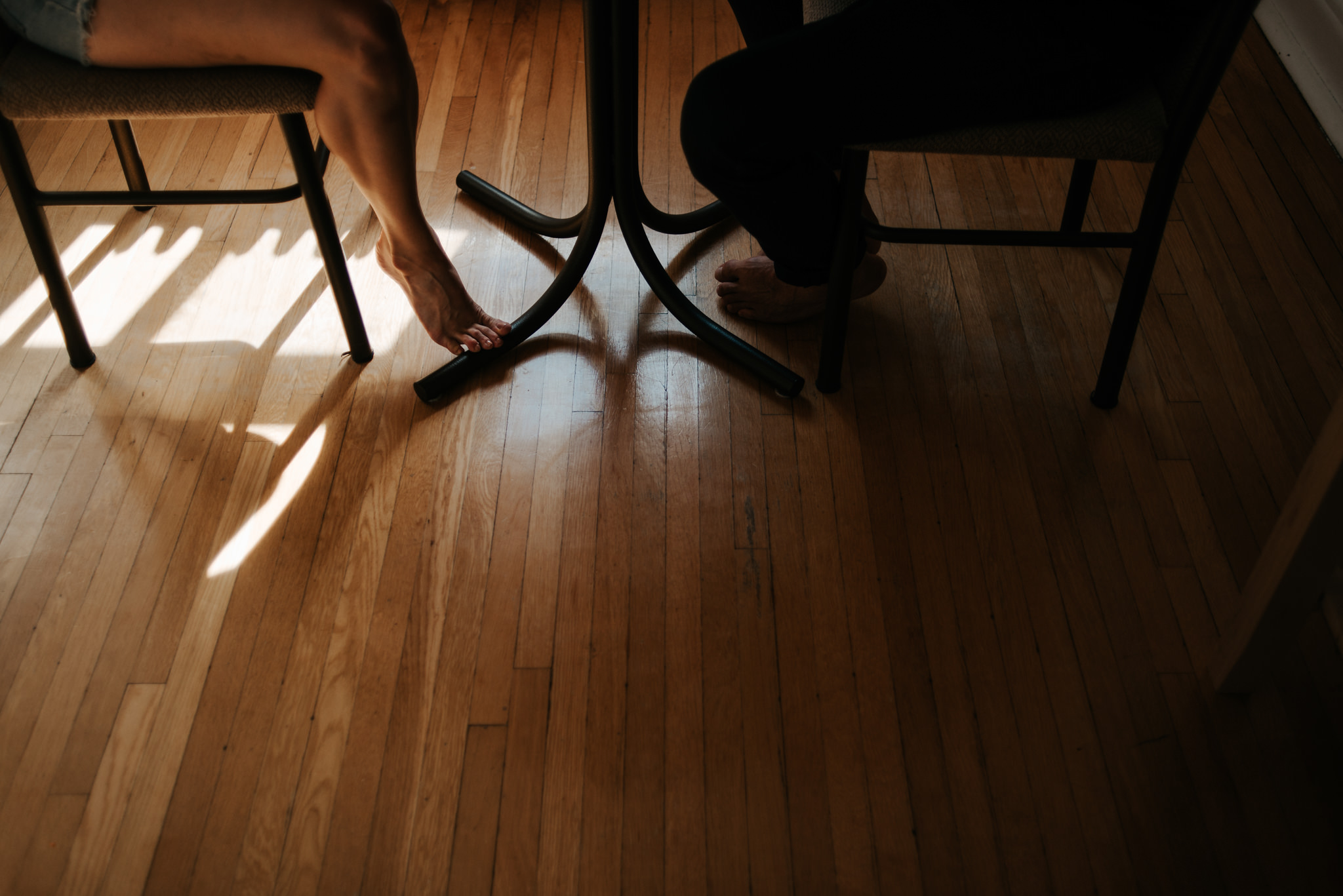 Couple feet while sitting at table in apartment