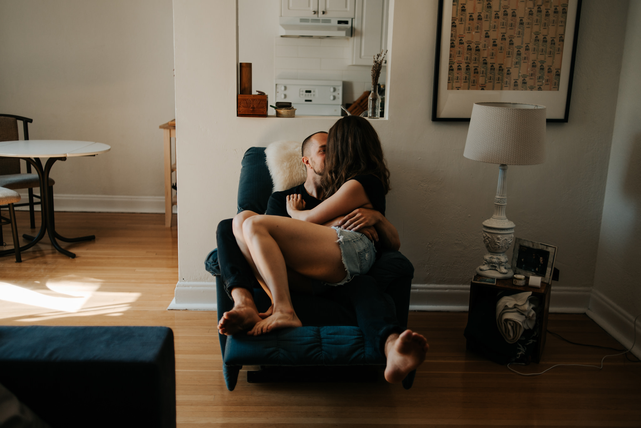 Girl sitting on guy in recliner chair in apartment