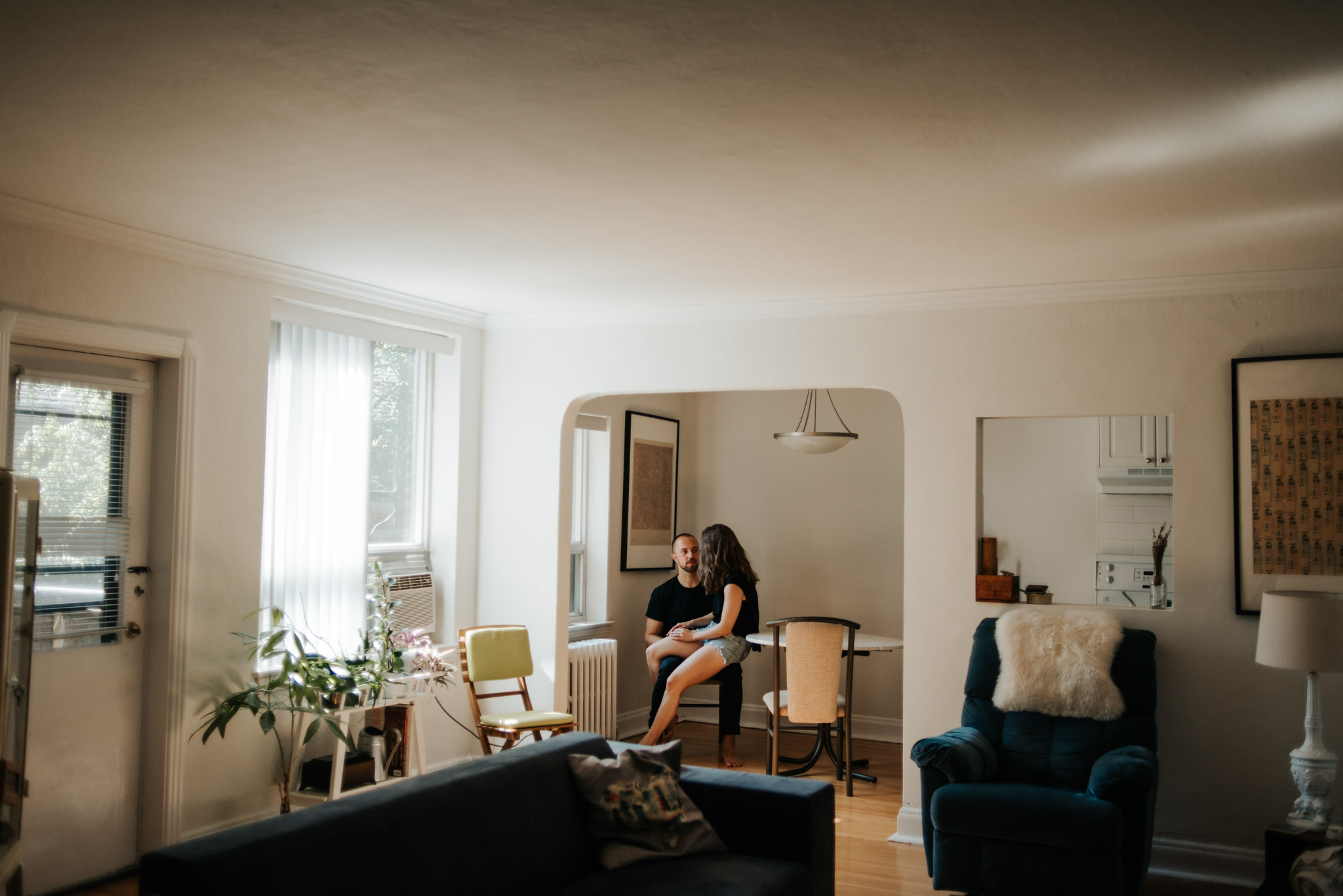 Couple sitting by window on chair in apartment kitchen