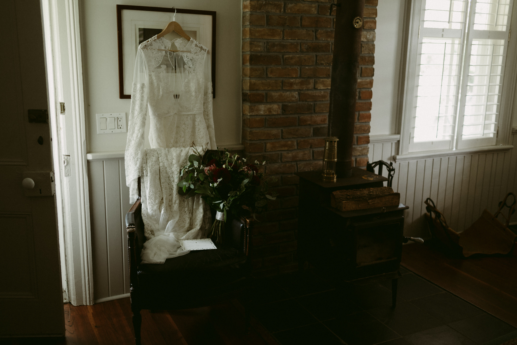 Lace Rue de Seine wedding dress hanging inside farm house