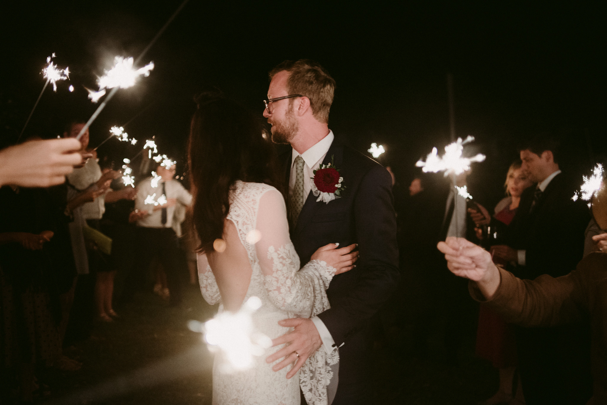 bride and groom kissing during sparkler exit