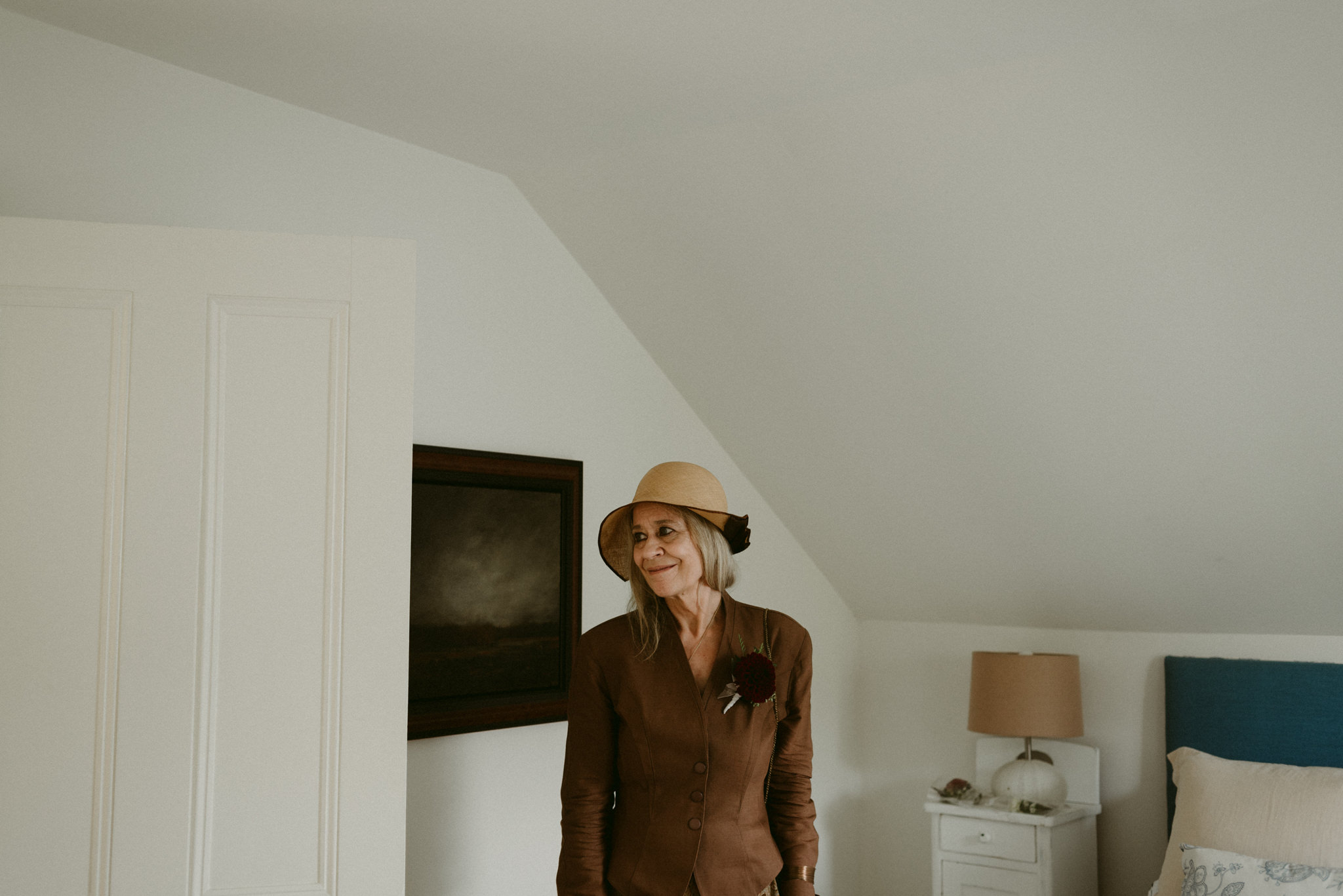 English woman in fascinator hat in white bedroom