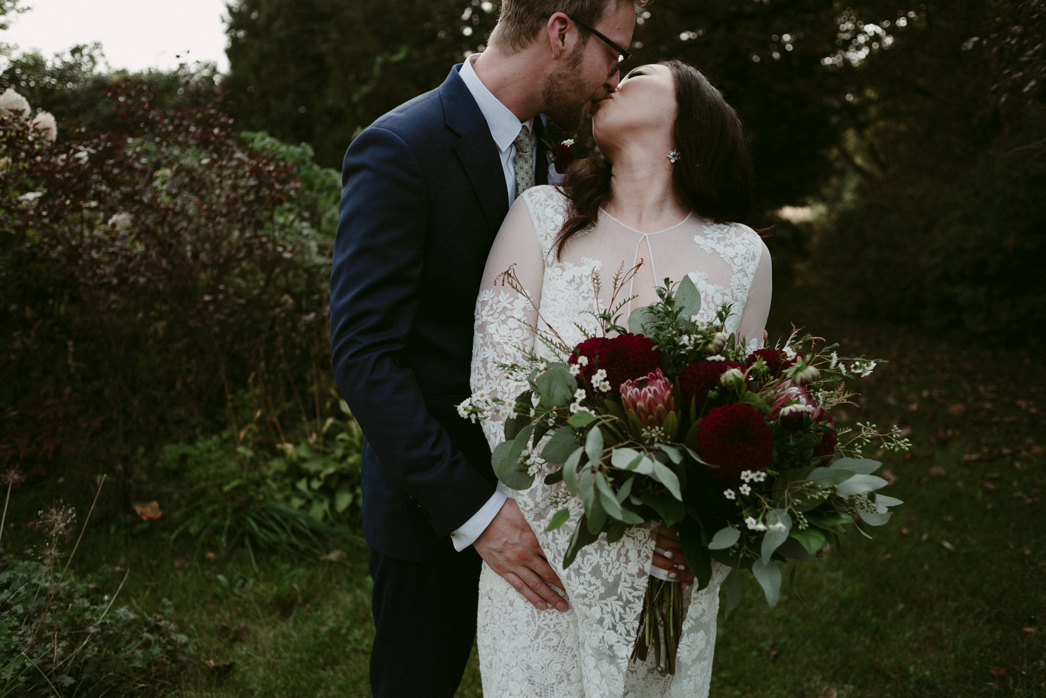 bride and groom kissing outside in garden