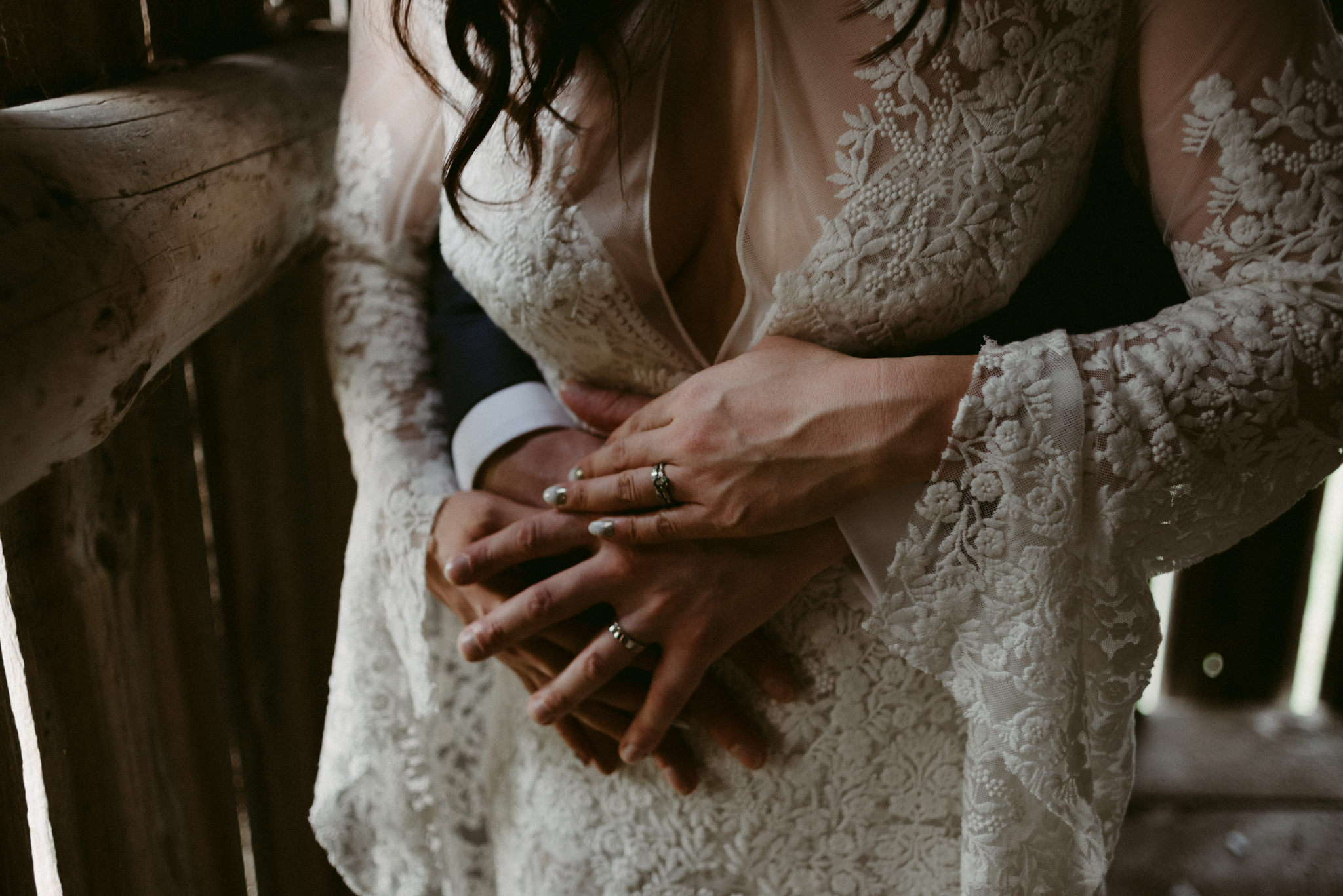 groom hugging bride from behind in barn