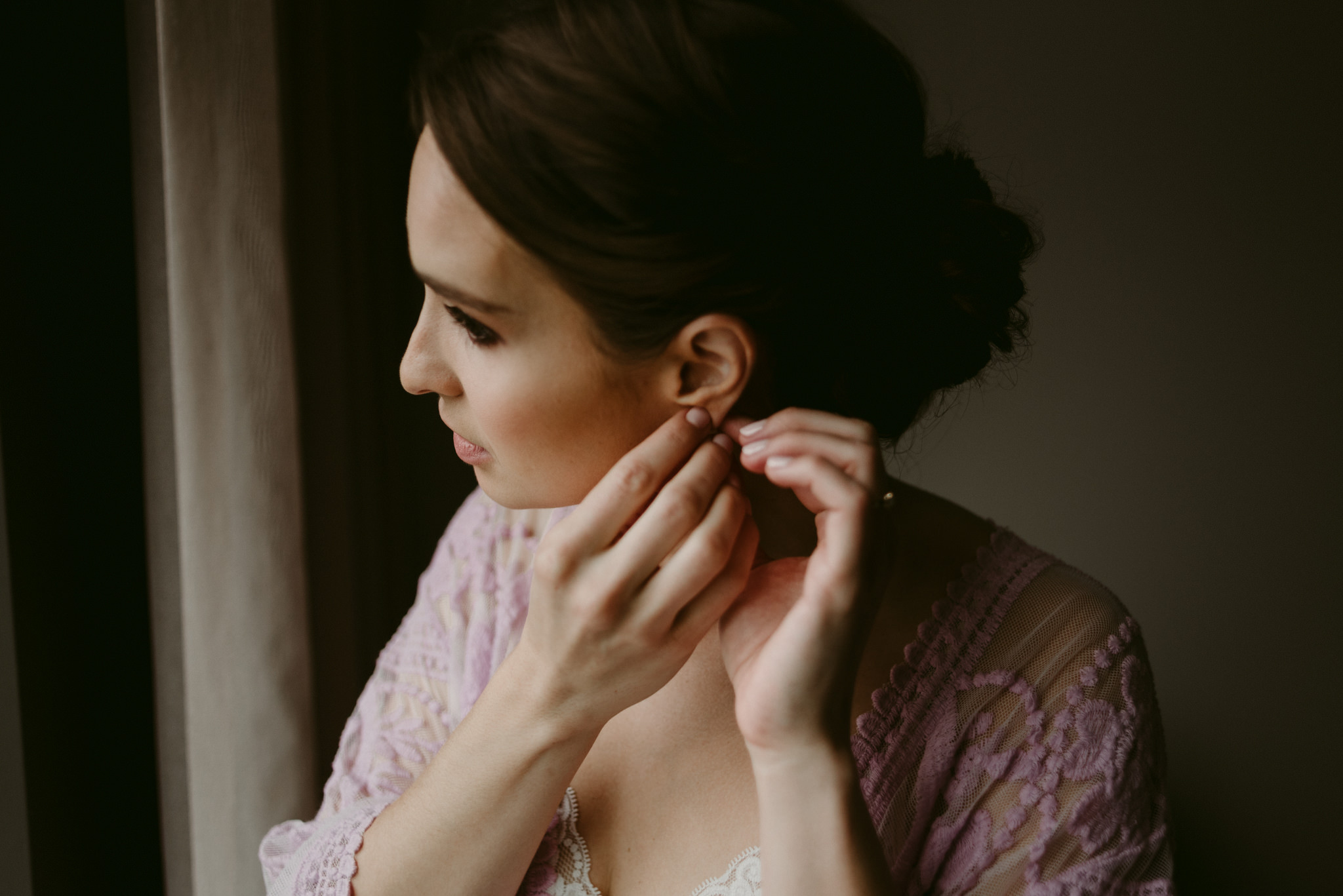 Bride putting on earrings