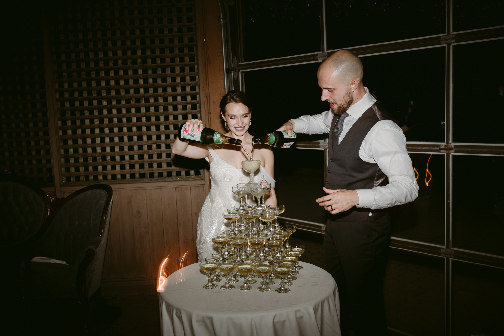 Bride and groom pouring champagne on champagne tower