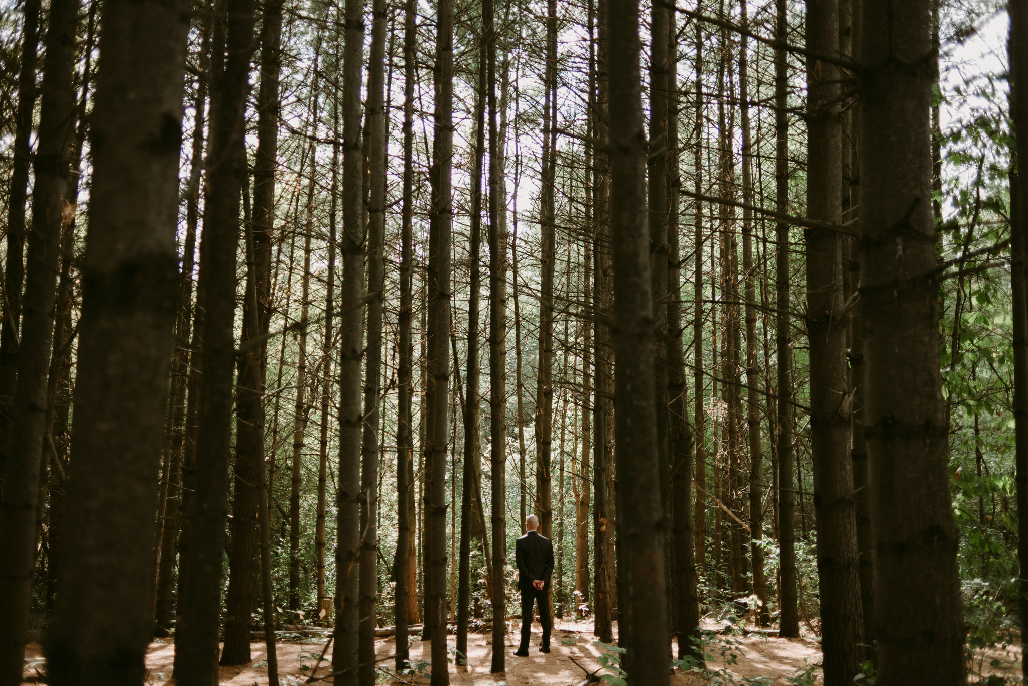 Groom waiting for bride in forest at Kortright Centre for Conservation