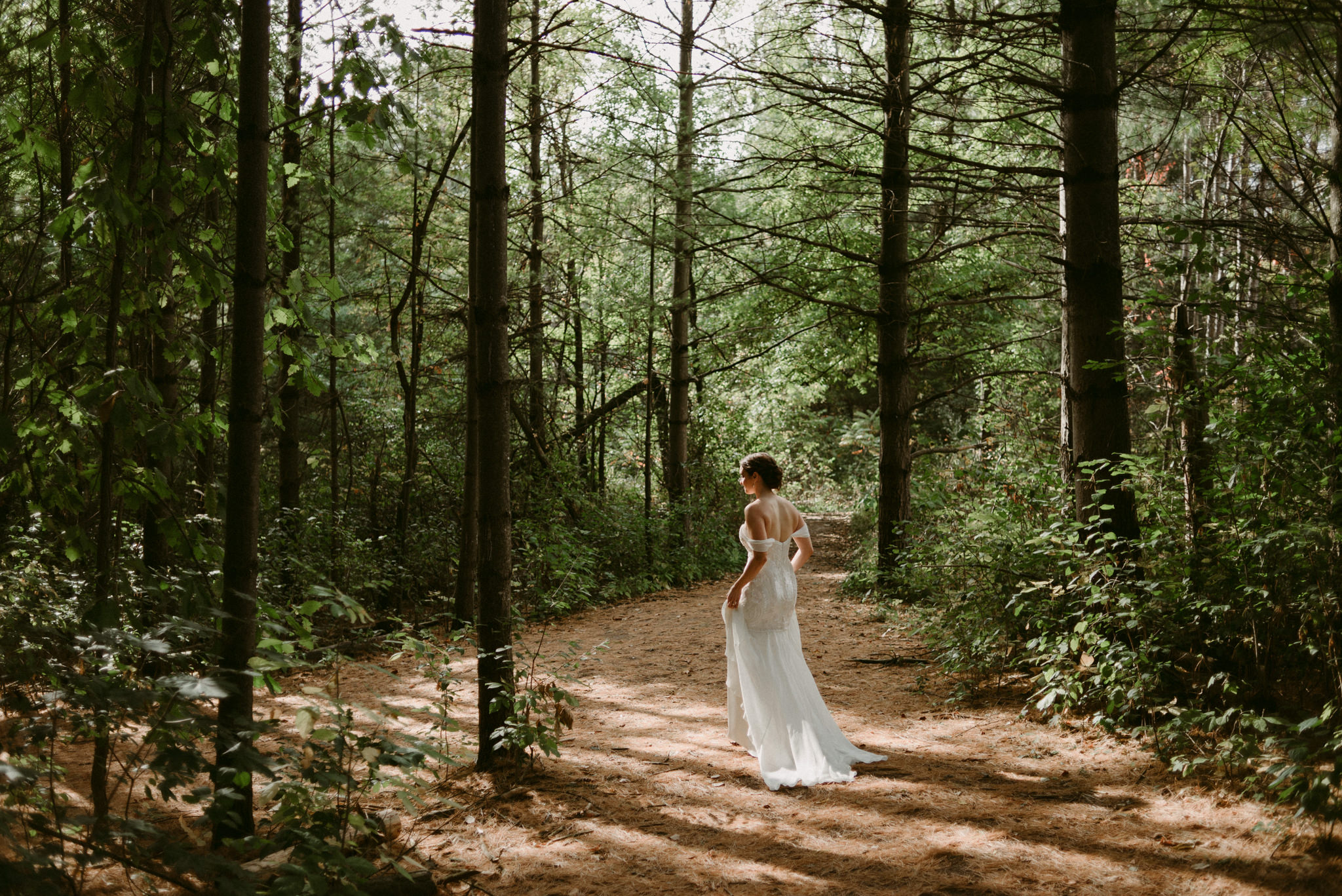 Bride walking in forest at Kortright Centre for Conservation