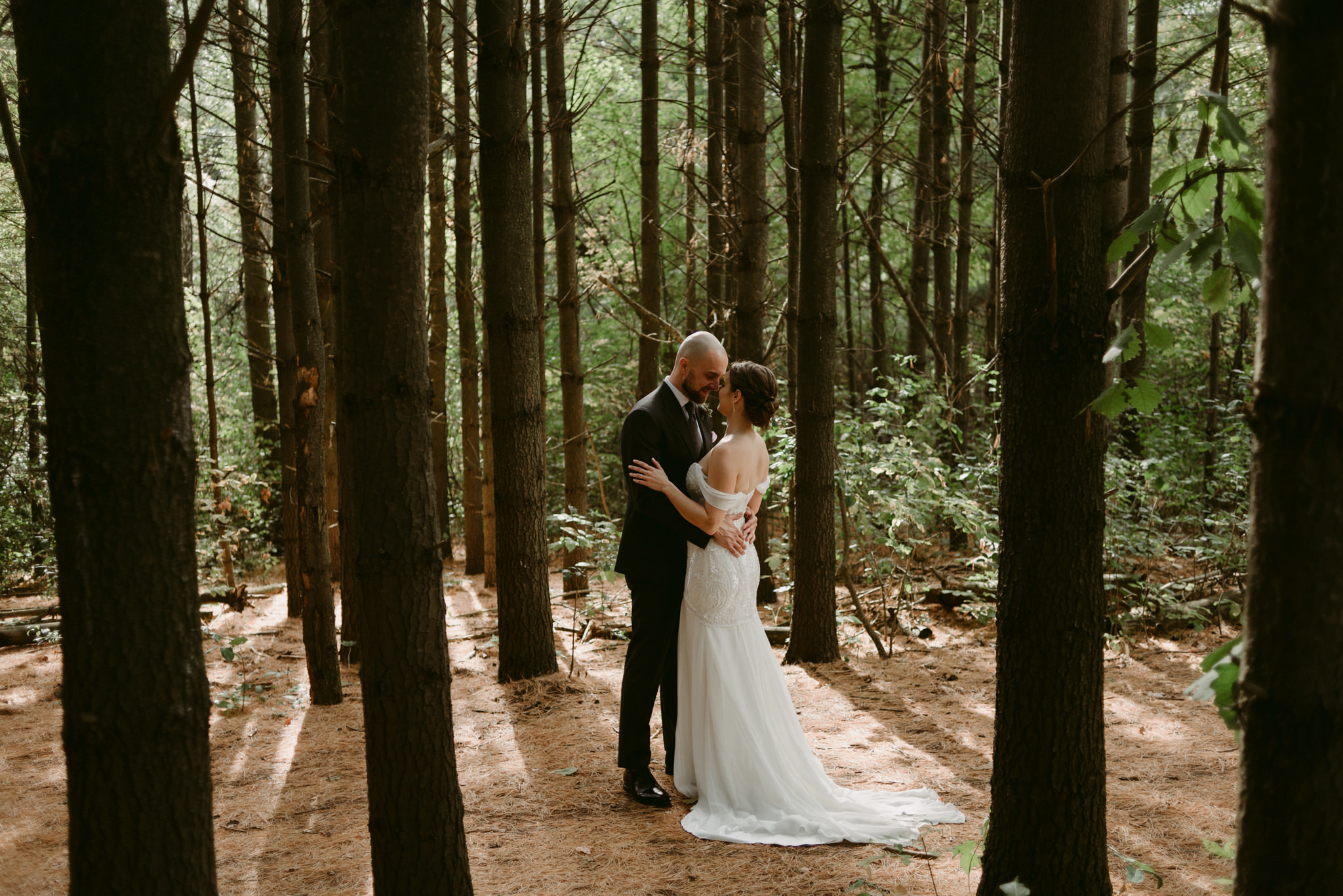Bride and groom hugging in forest