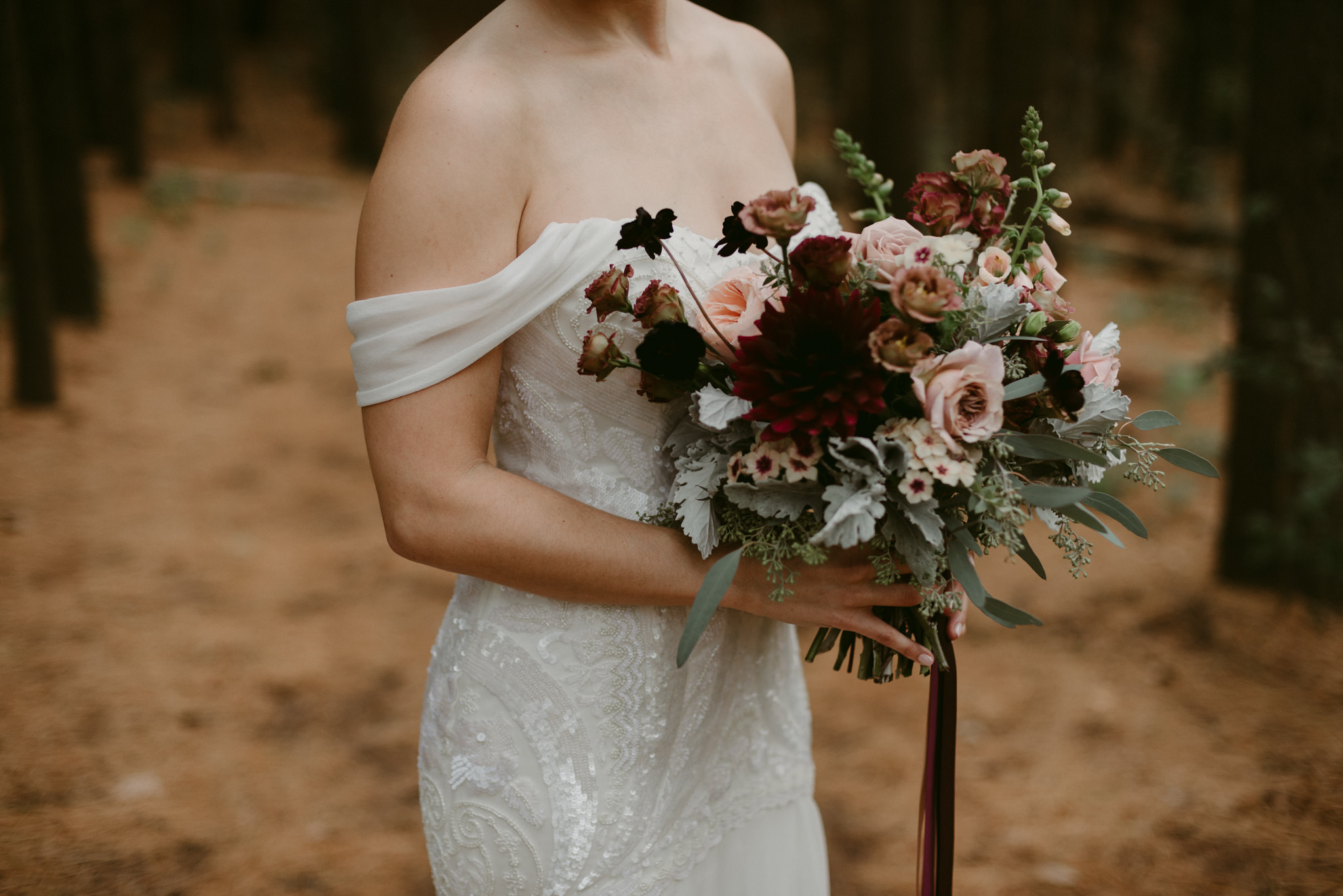 Bride holding romantic maroon and pink bouquet