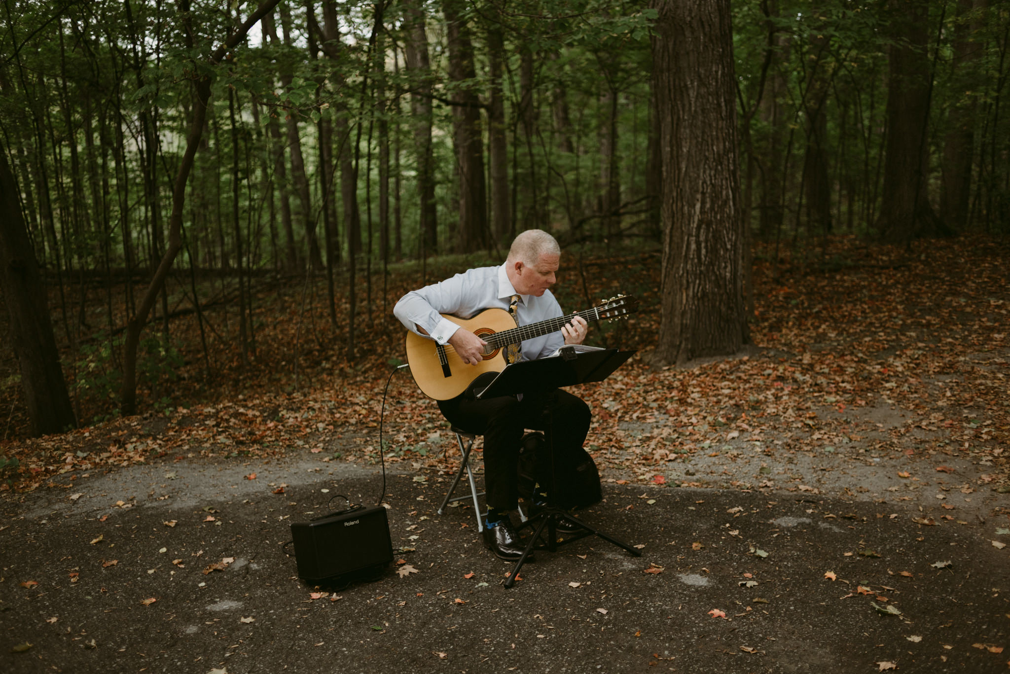 Musician playing guitar in forest before ceremony