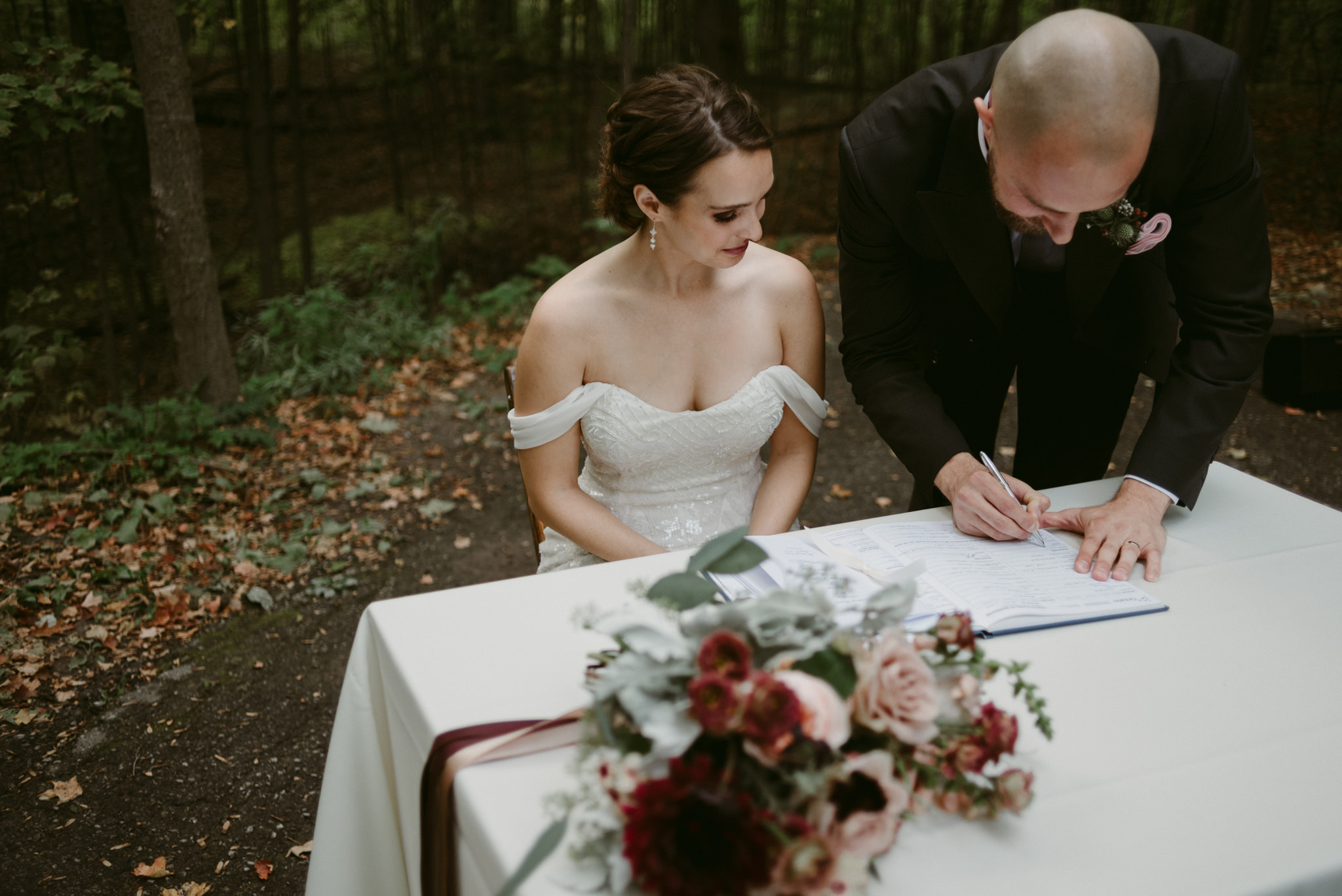 Bride watching groom signing marriage license