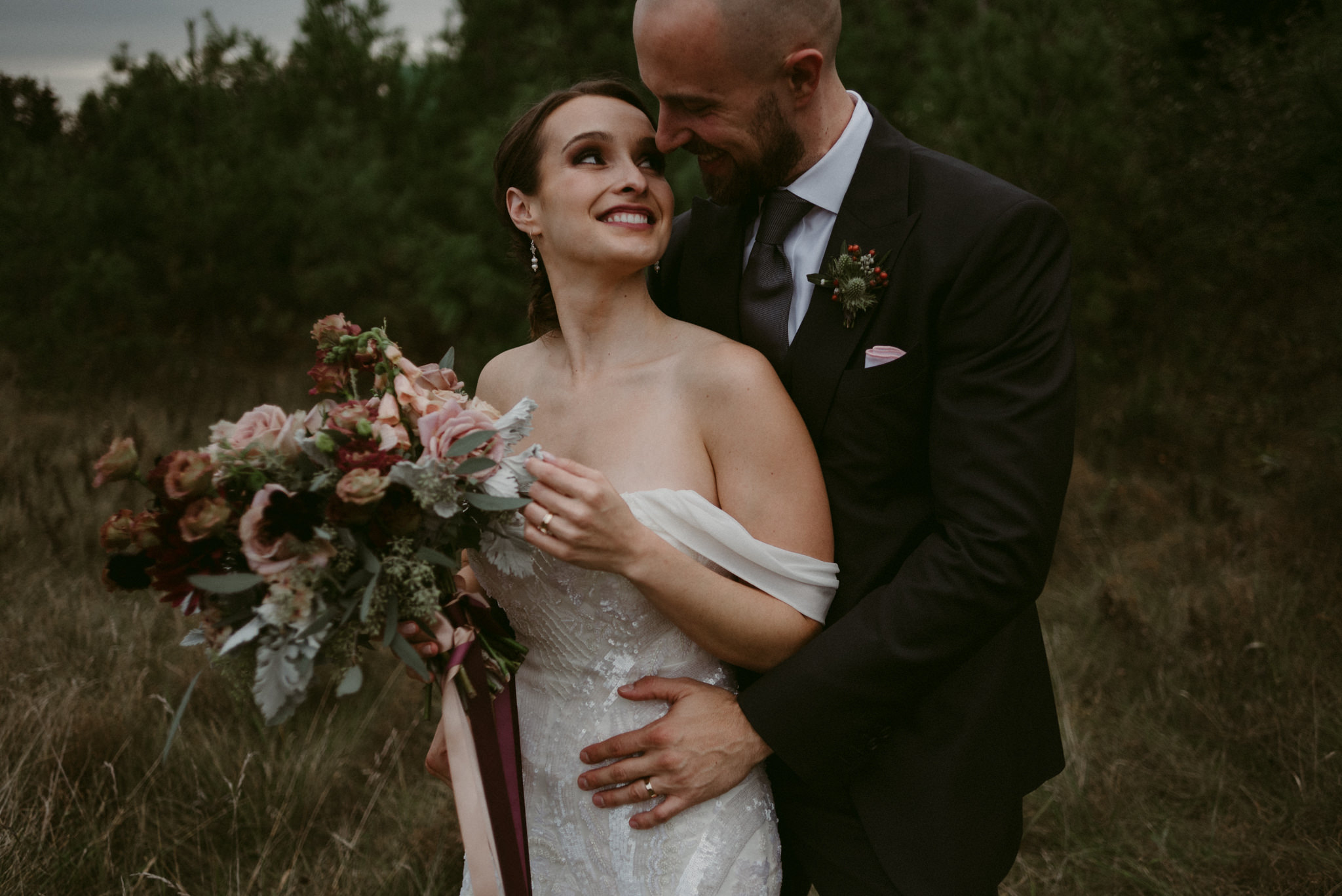 Groom hugging bride from behind