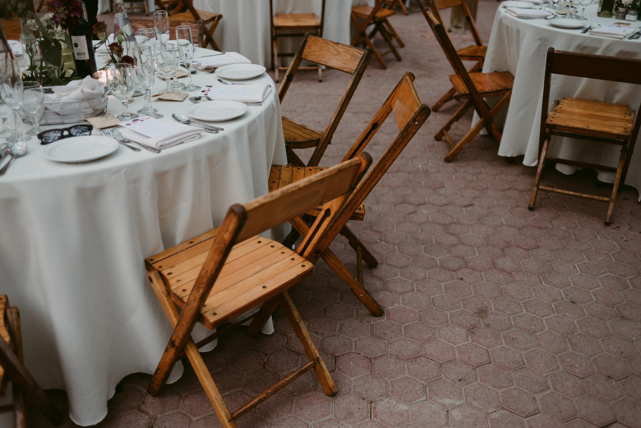 Round tables with white table clothes and wooden chairs