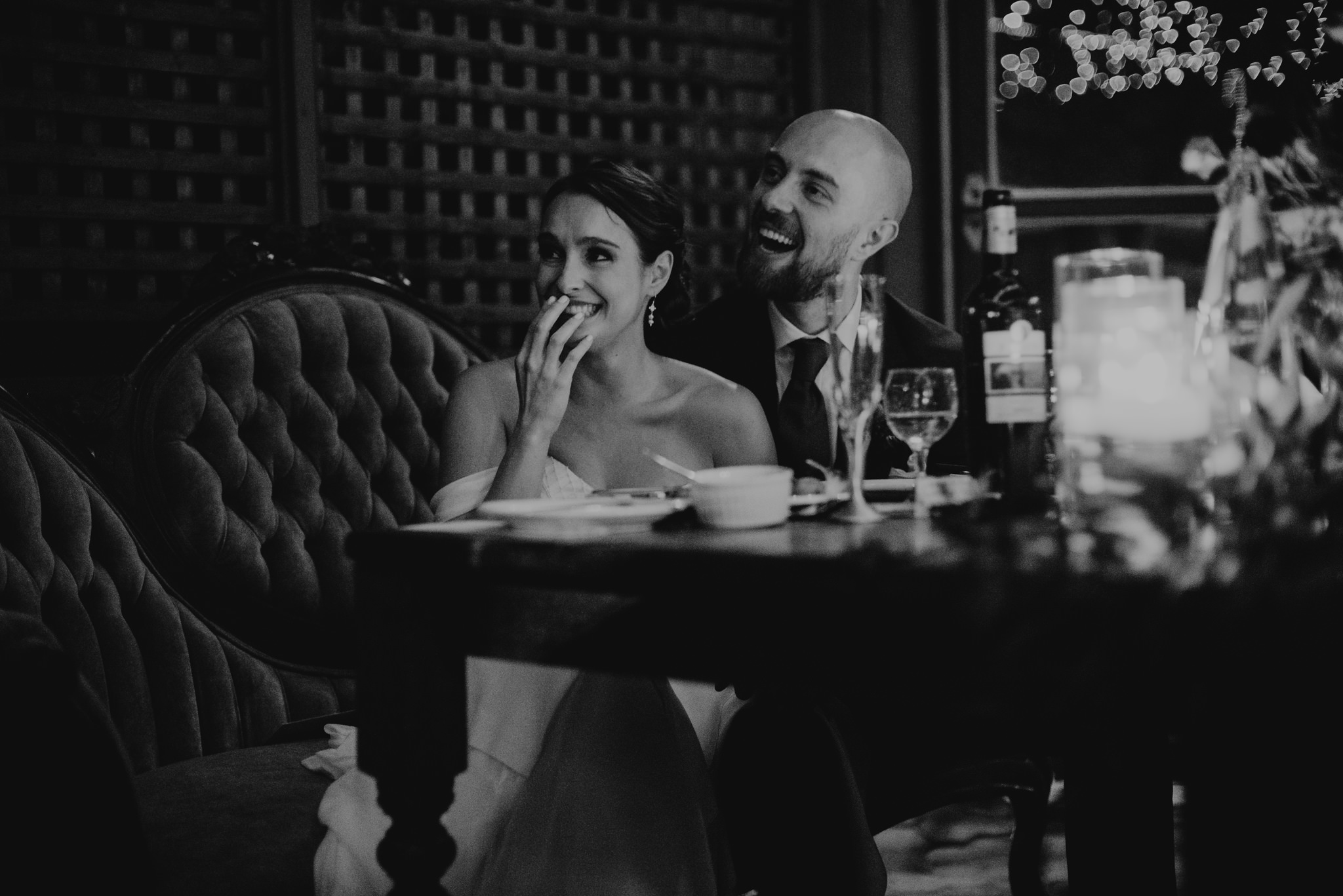 Bride and groom laughing during speeches at wedding