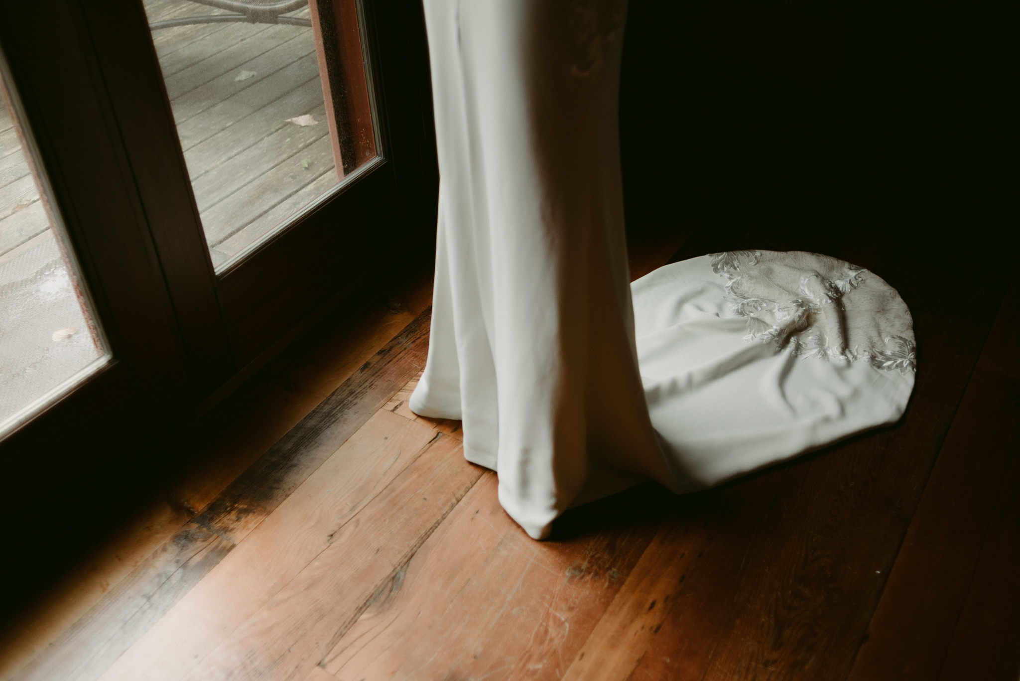 Bride wedding dress train on wood floor by door