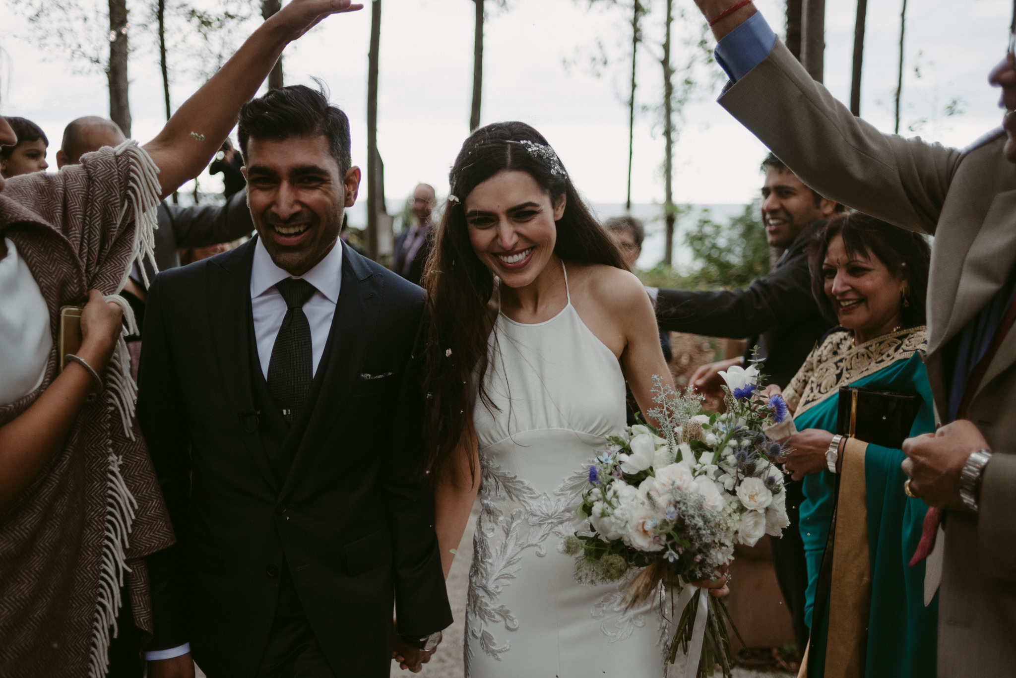 bride and groom showered with flowers during recessional