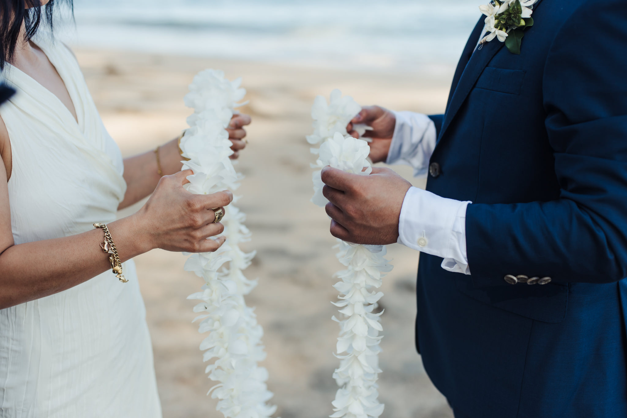 bride and groom holding lei