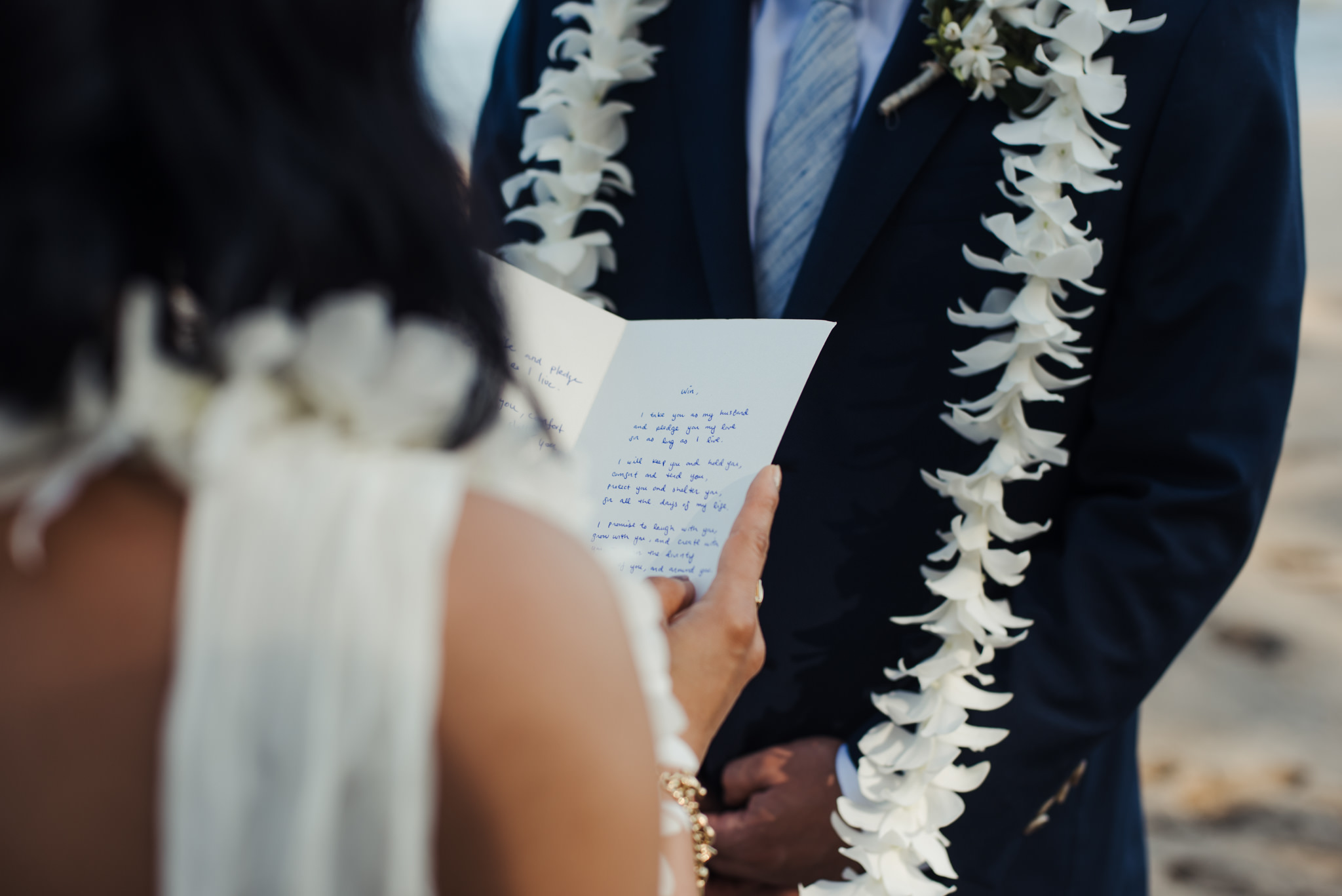 bride reading vows to groom on beach