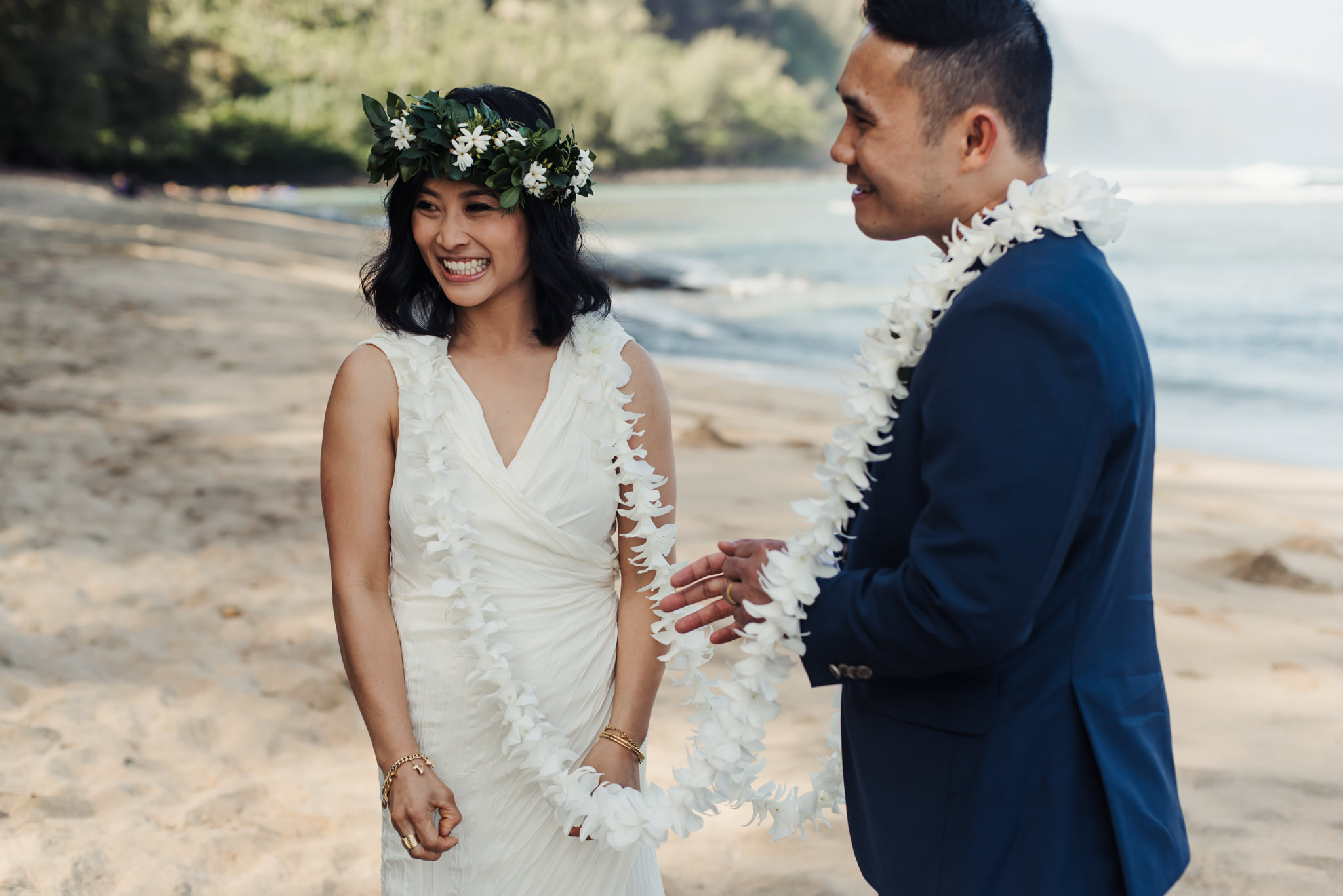 bride and groom smiling during wedding ceremony on beach