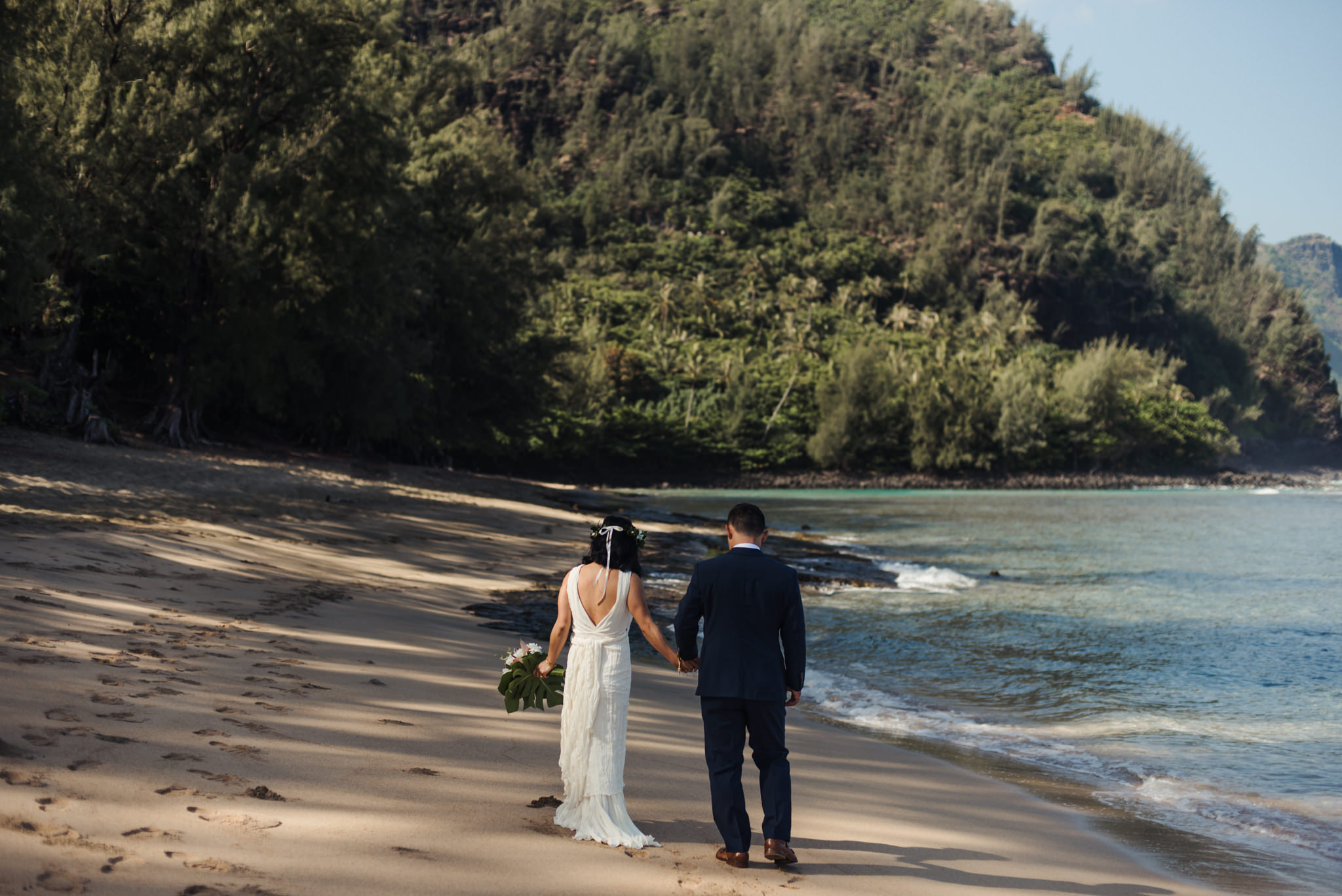 bride and groom walking on beach