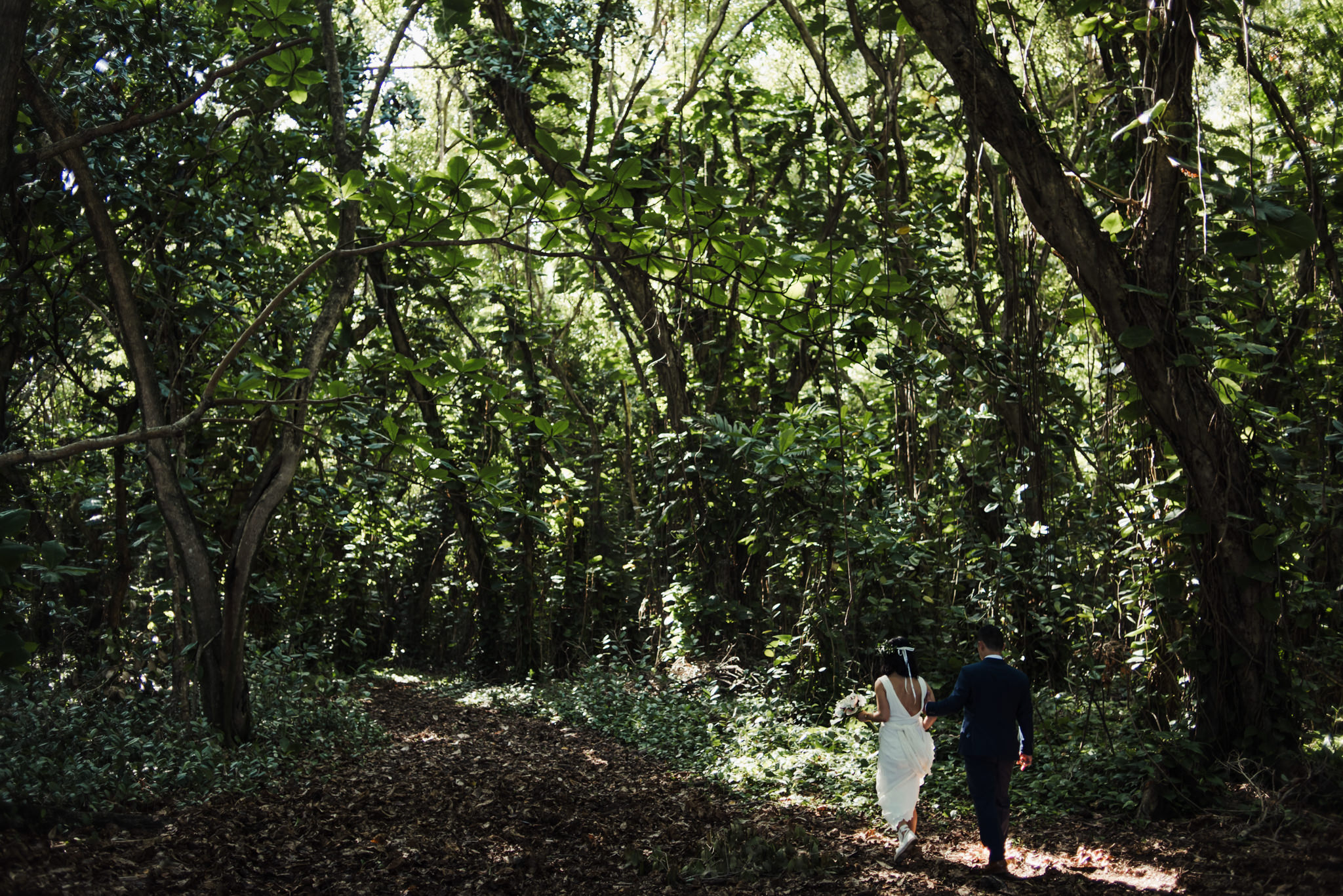 bride and groom walking in tropical forest