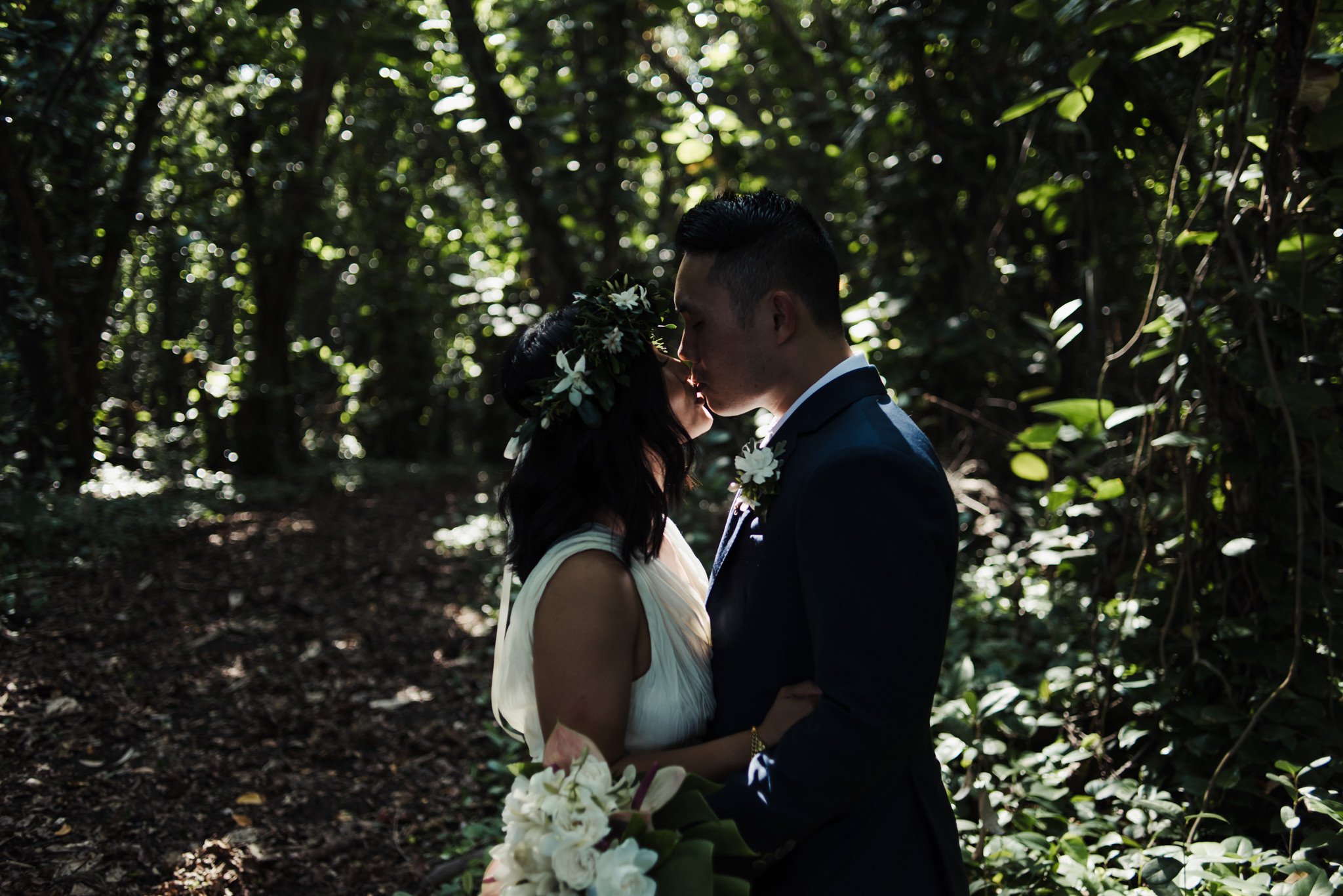 bride and groom kissing in tropical forest