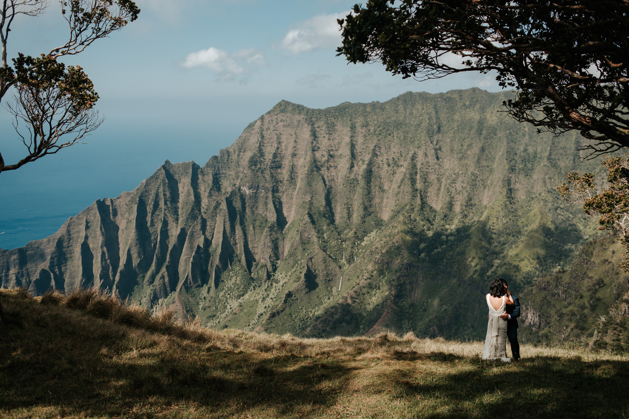 bride and groom hugging with view of na pali coast