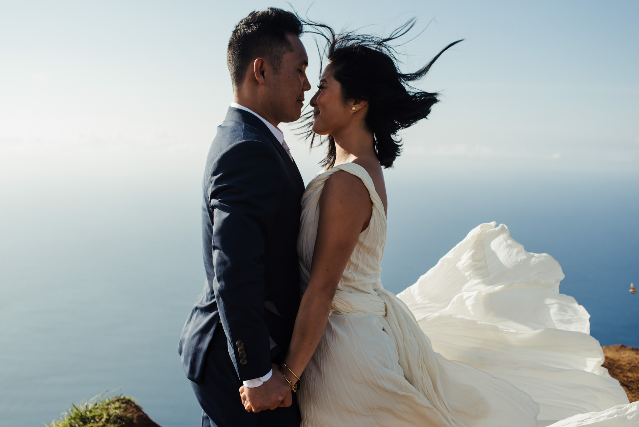 bride and groom holding hands in wind