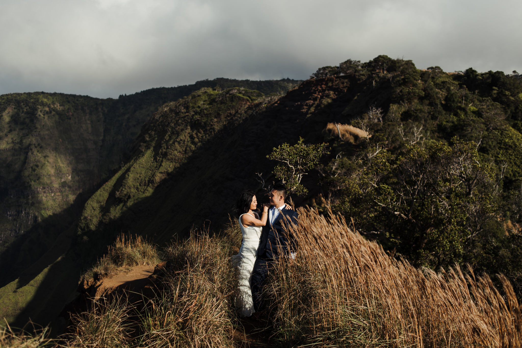 Bride and groom standing in front of cliffs in Kauai elopement