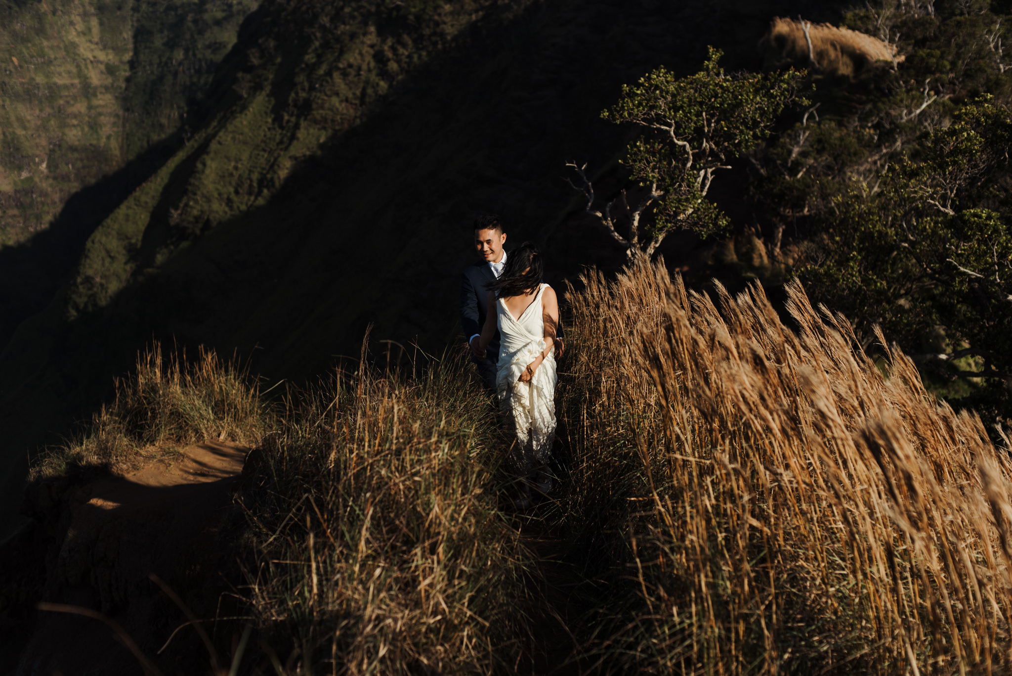 Bride and groom walking on hiking trail in Kokee State Park