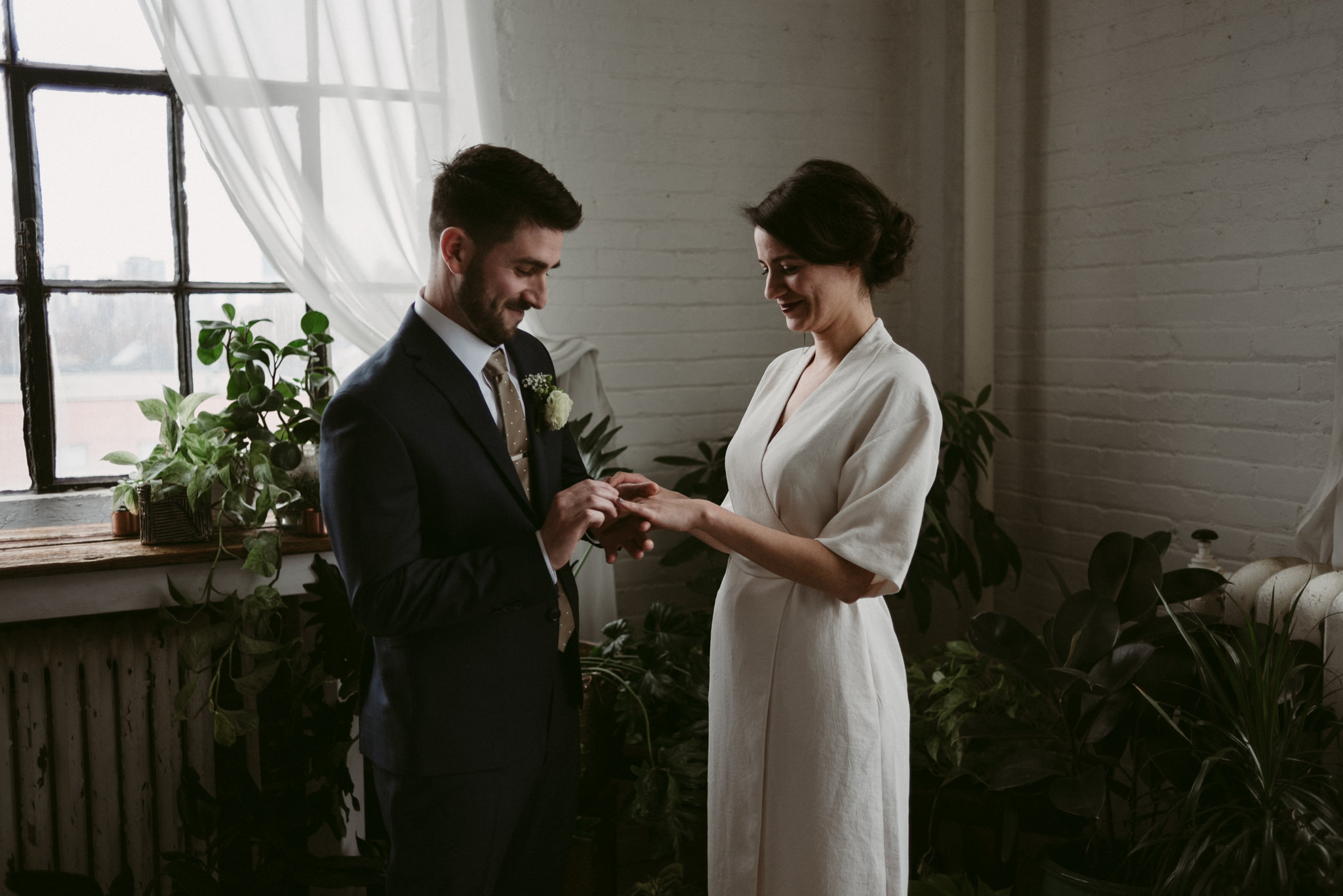 Groom putting ring on bride's finger