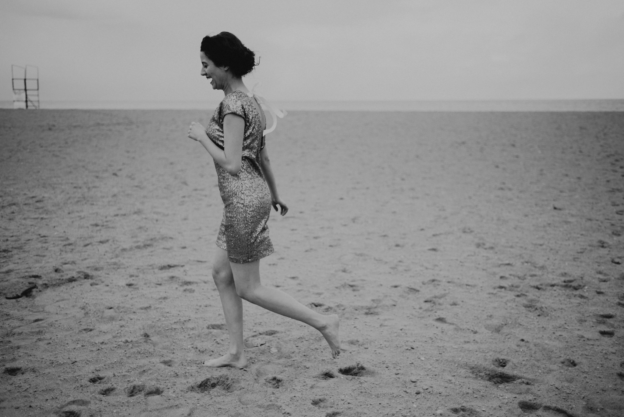 Bride running on the beach barefoot