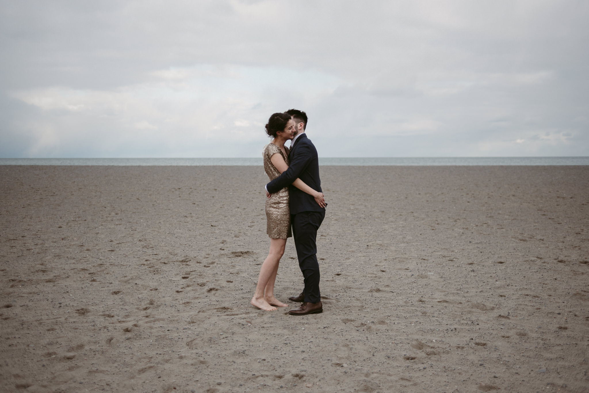 Bride and groom hugging on the beach