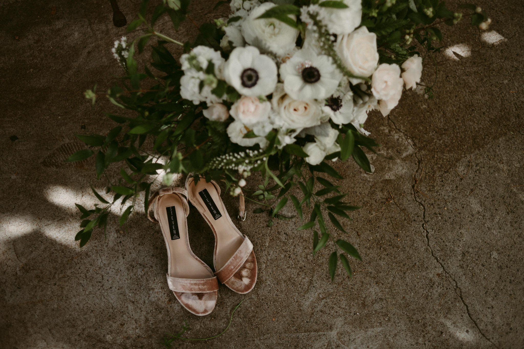 velvet shoes and wedding bouquet on concrete floor