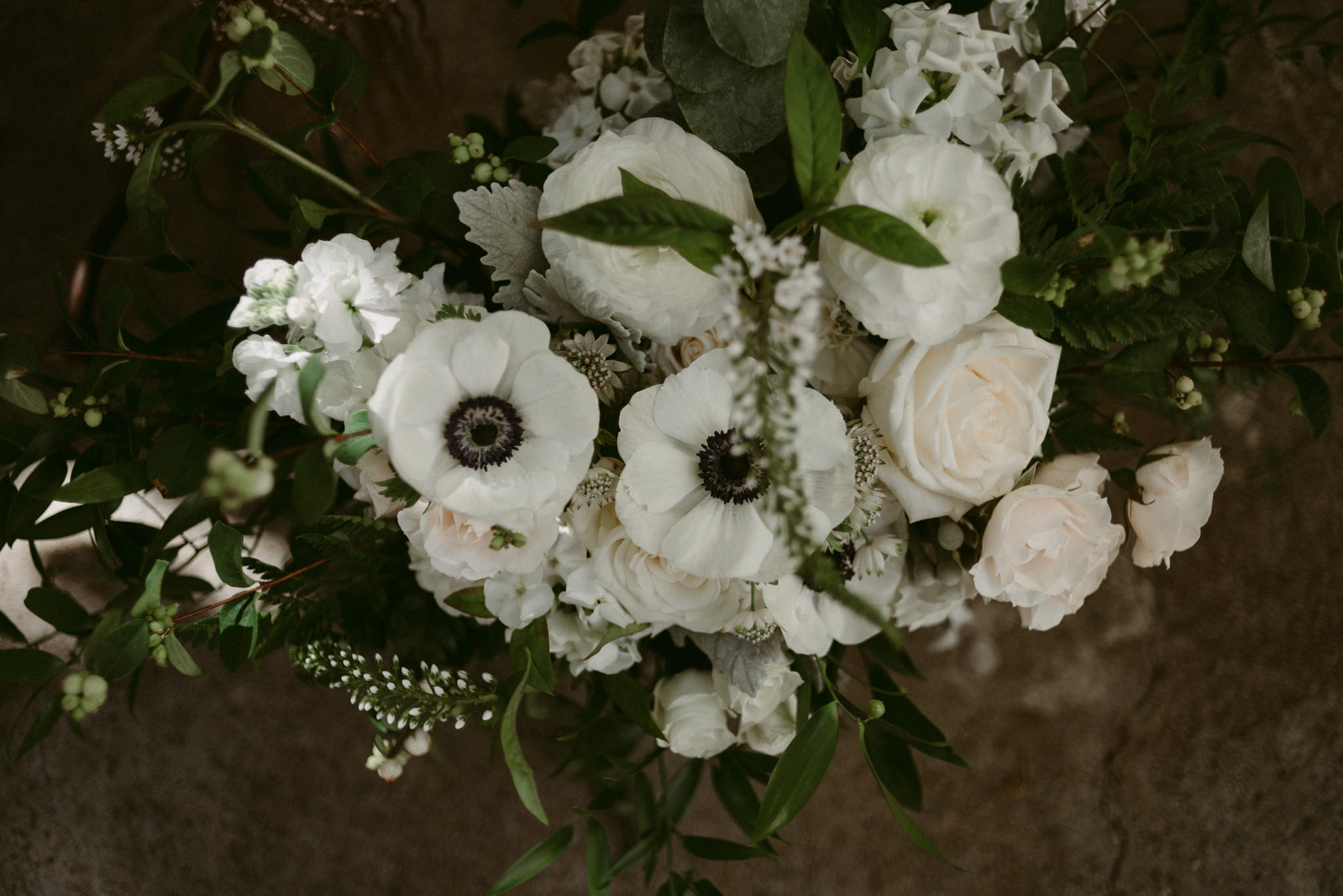 close up of white roses and poppies in wedding bouquet