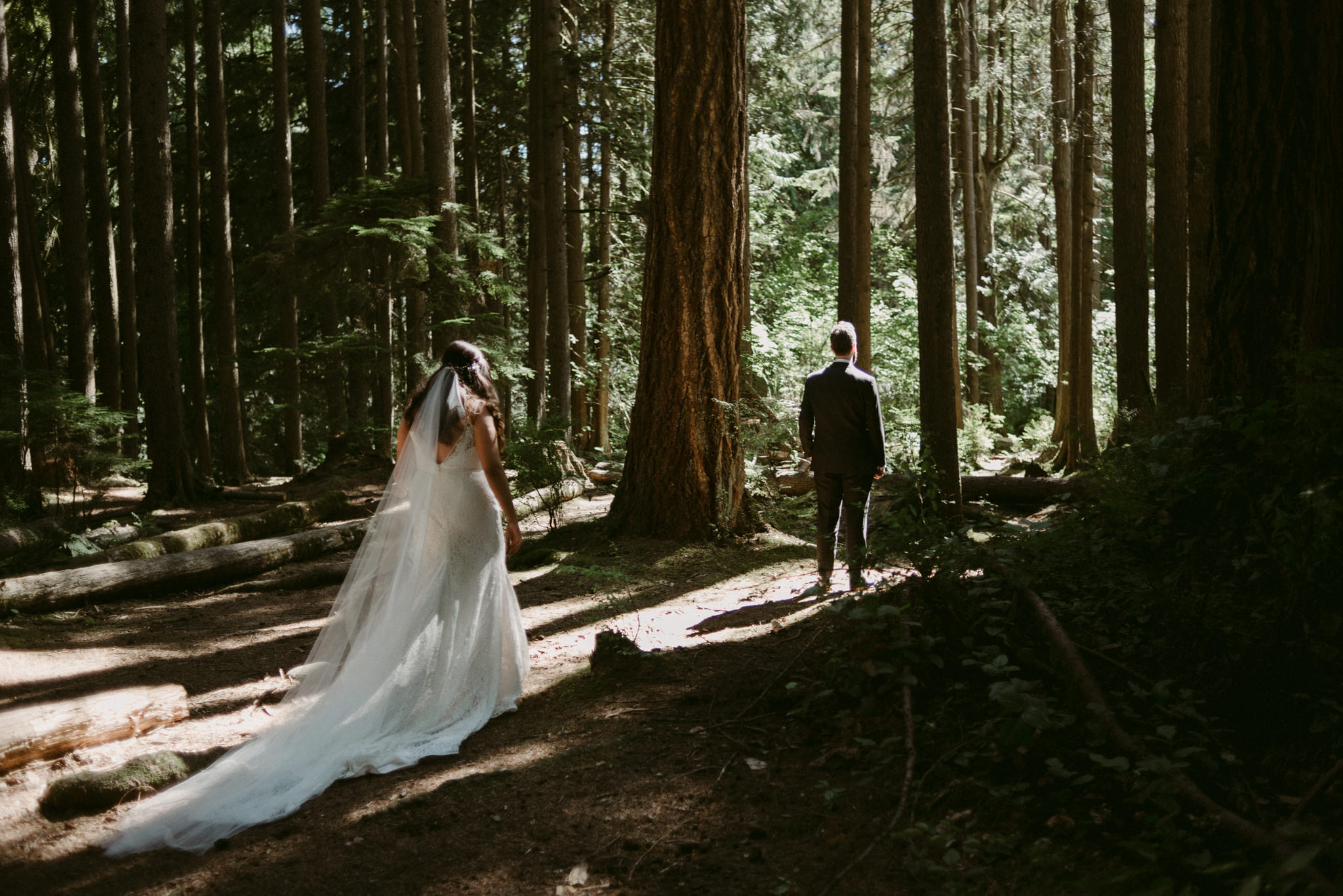 bride walking up to groom in forest for first look