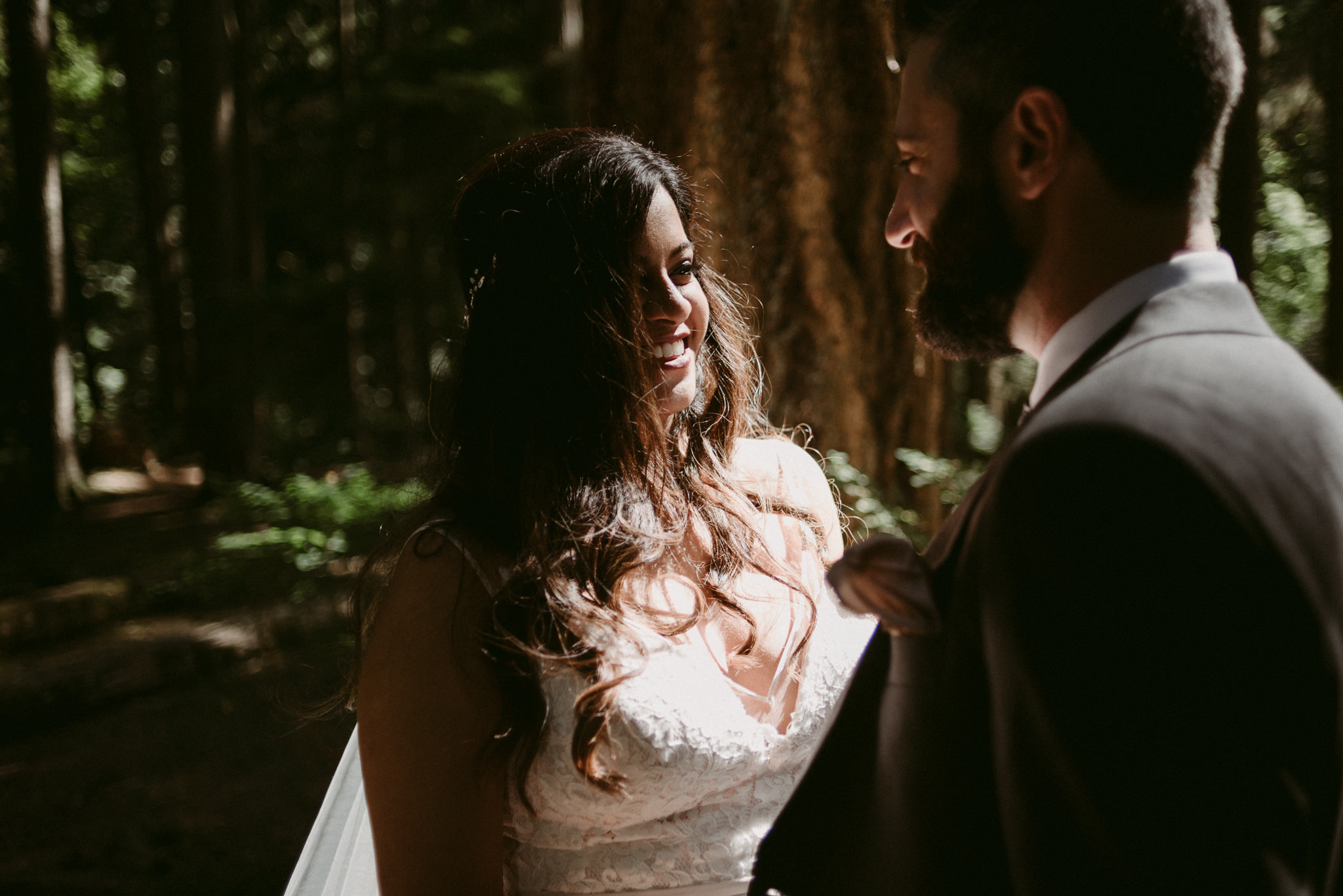 bride smiling at groom in forest