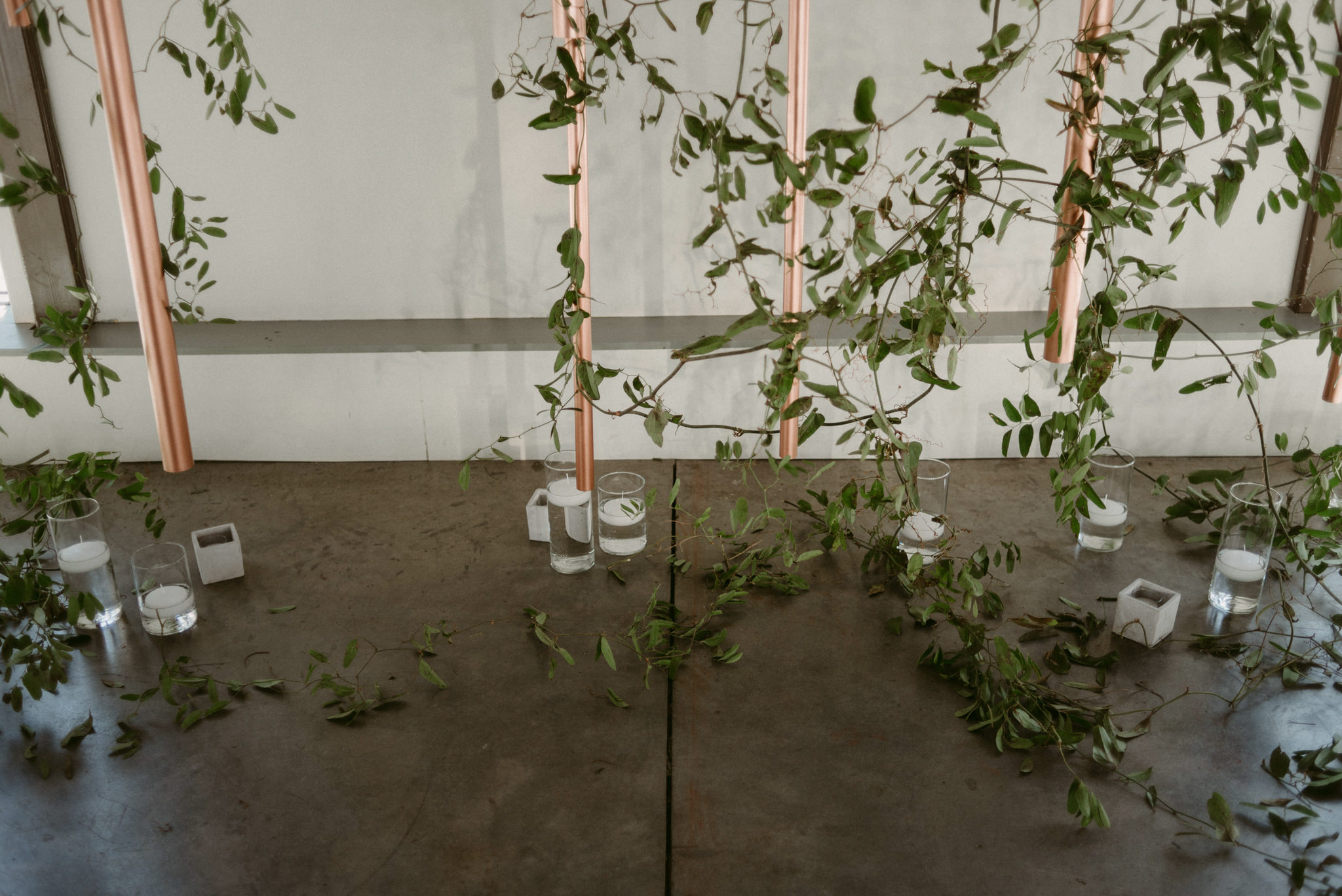 copper and vine backdrop with candles on concrete floor