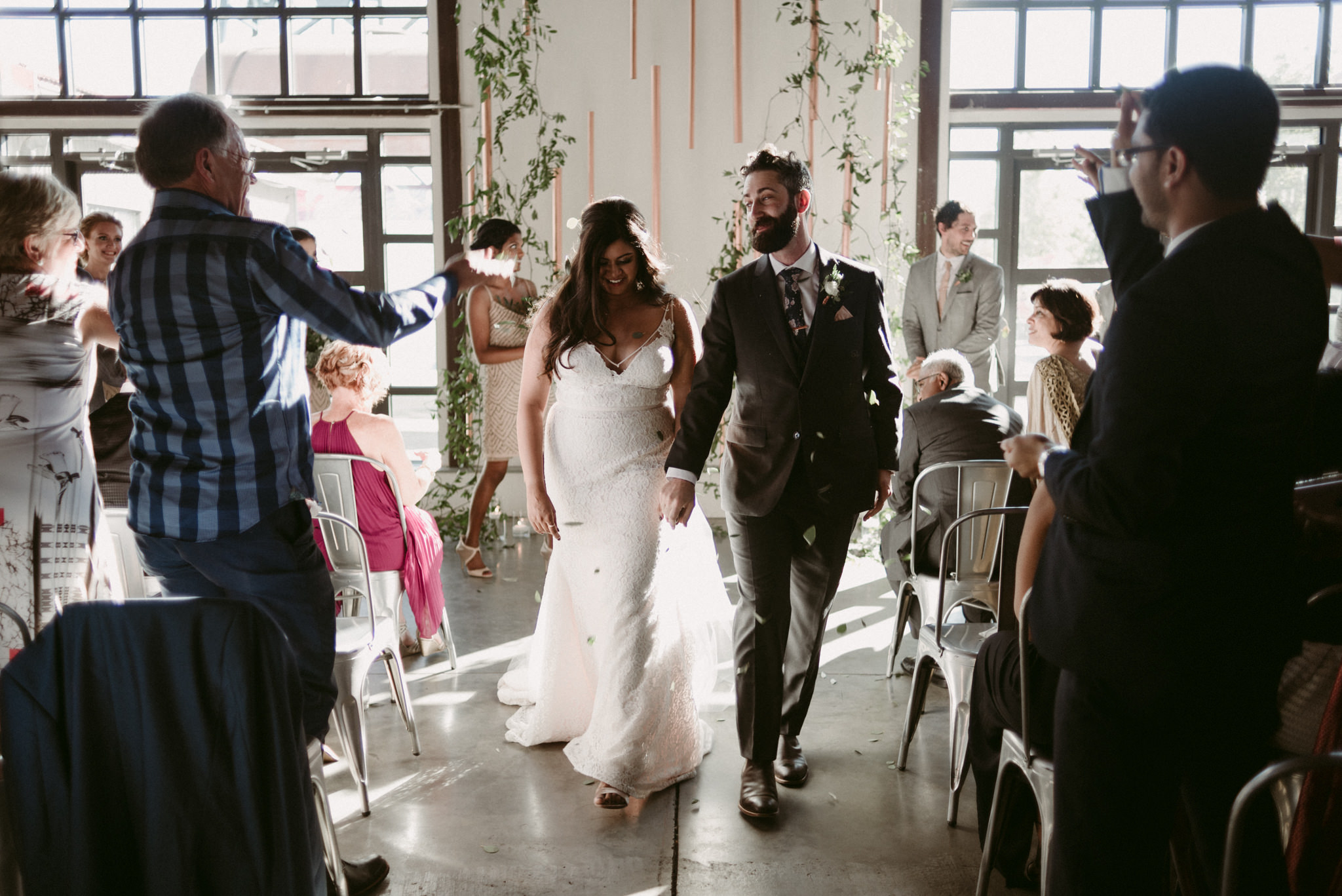 bride and groom walking down aisle and flowers thrown at them