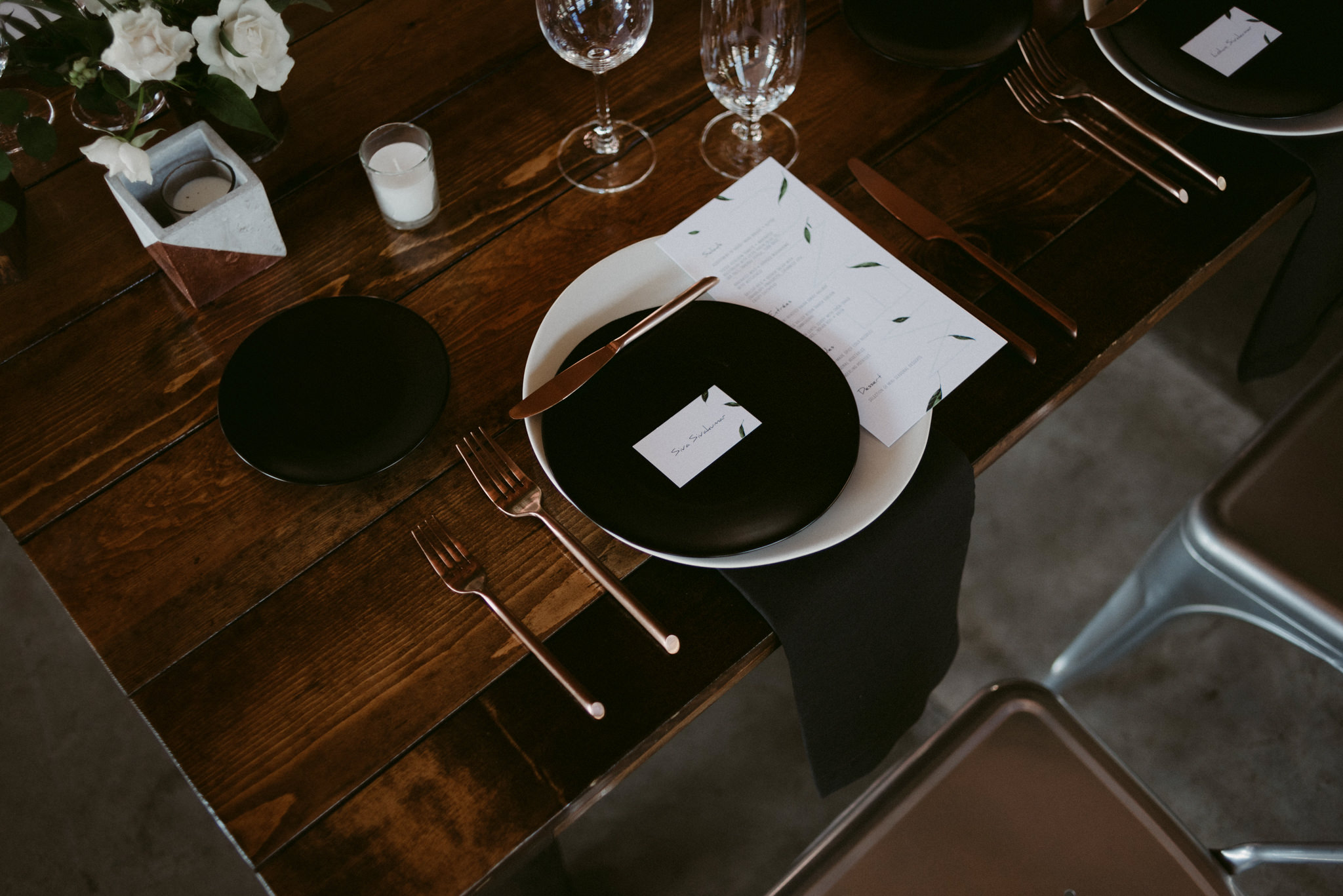 copper utensils, black plates on wood table