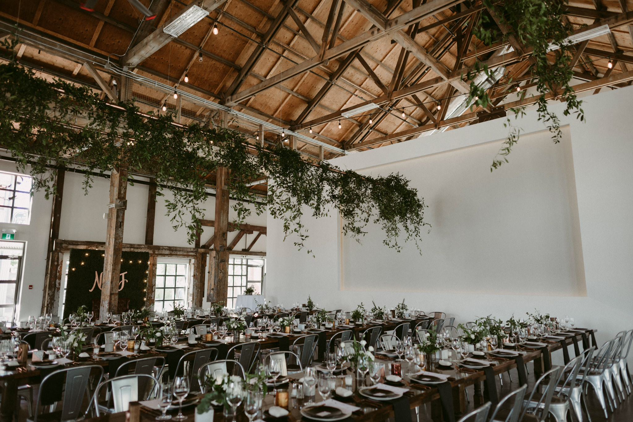 hanging vines and table seting in industrial wedding venue