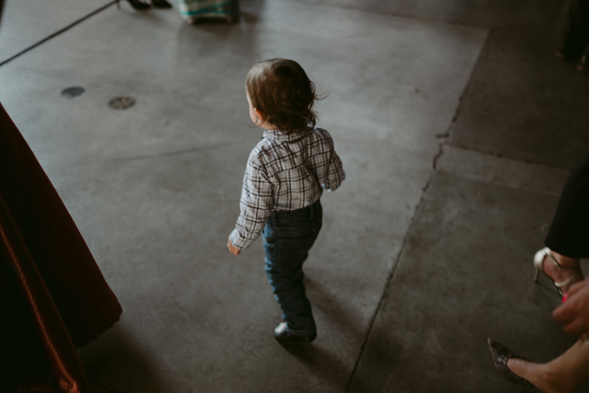 little boy walking on concrete floor at wedding