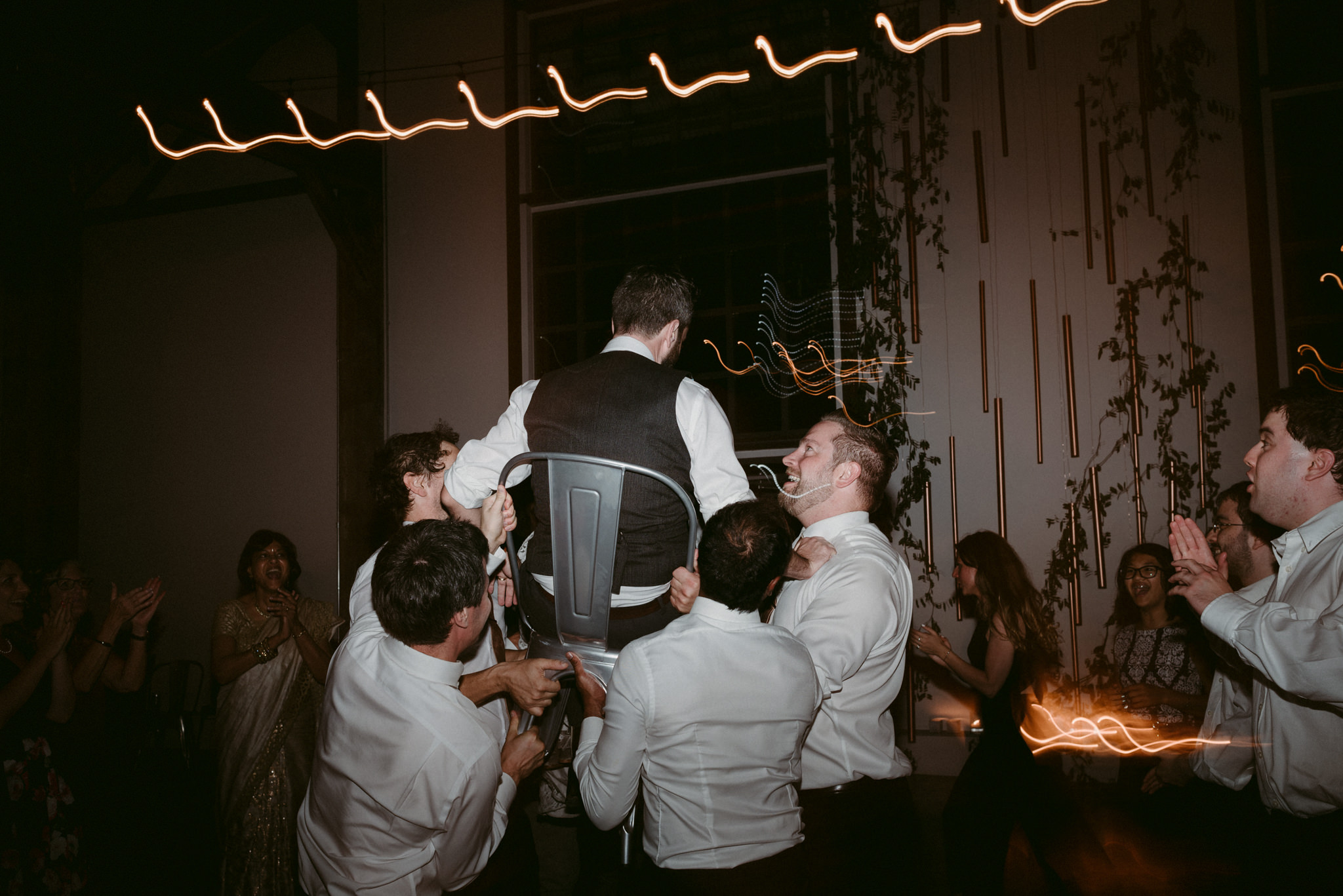 groom on chair during wedding reception