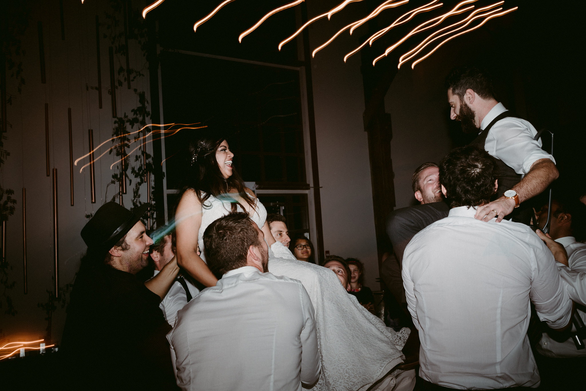 bride and groom hoisted up on chair