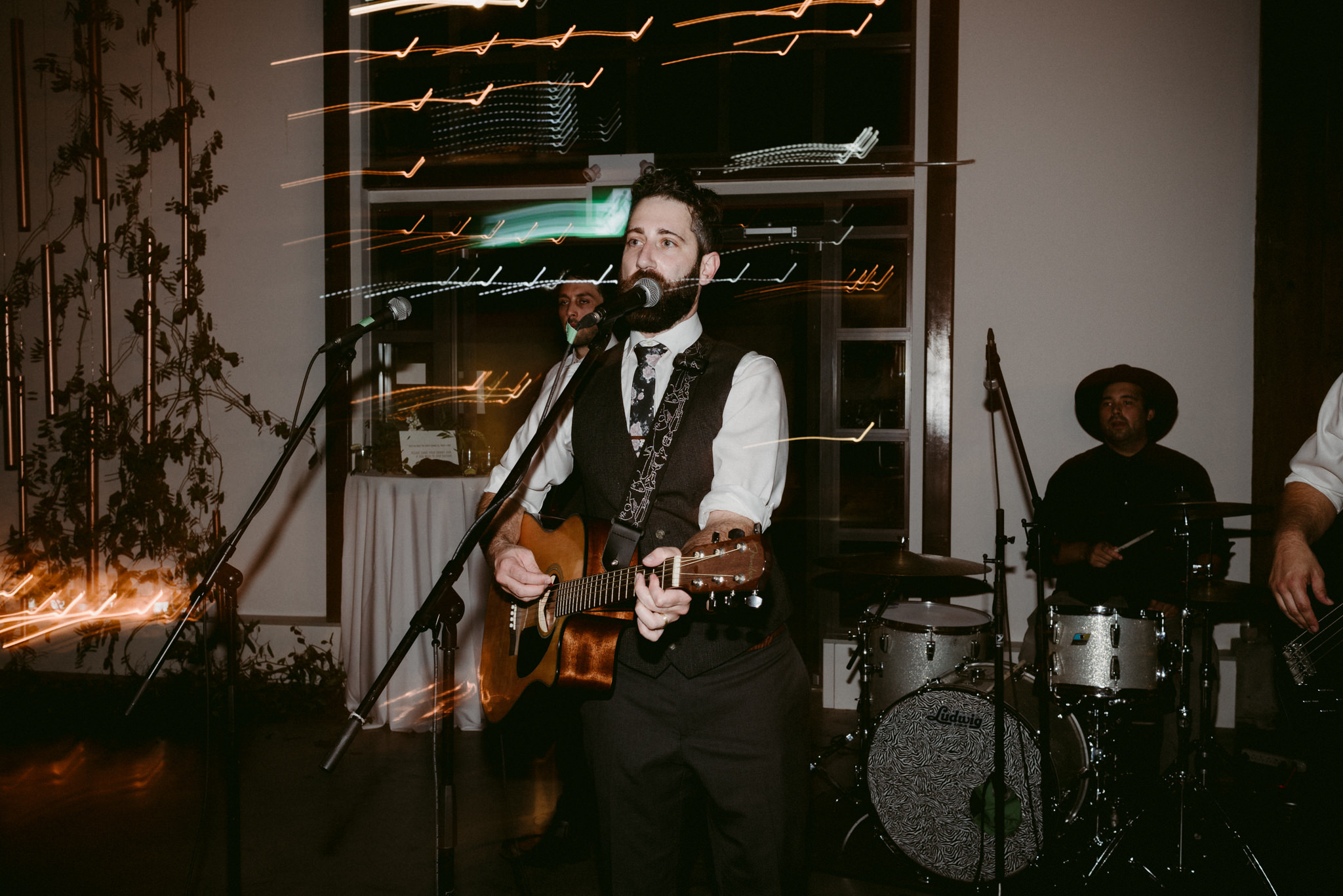 groom playing guitar and singing during wedding reception