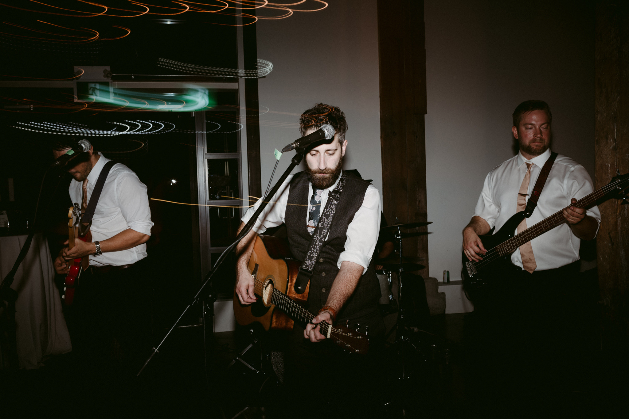 groom playing guitar during wedding reception