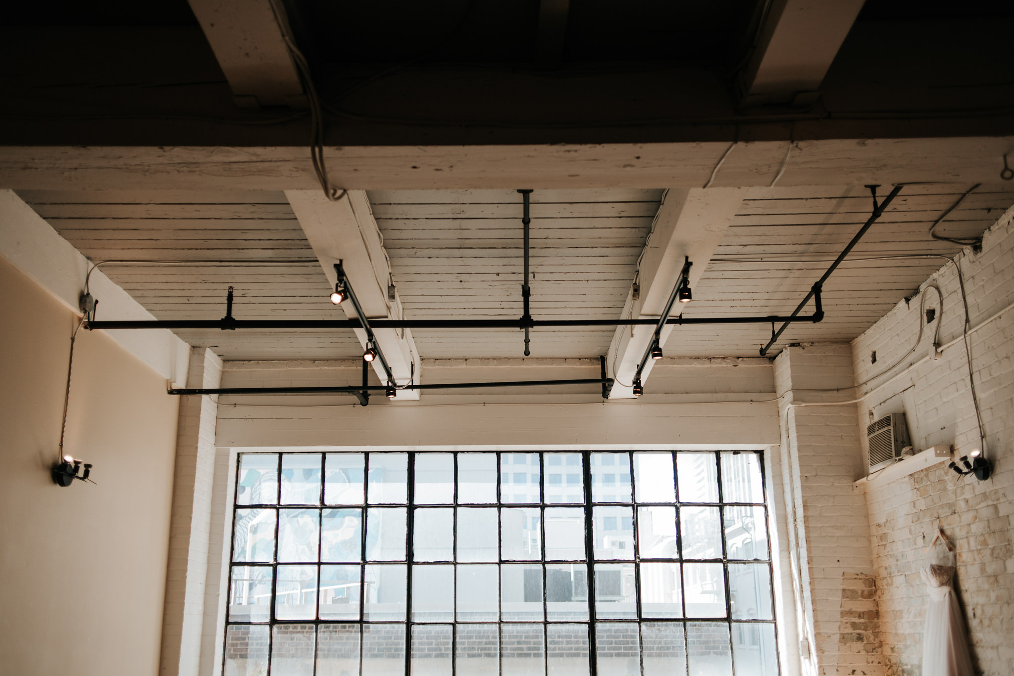 Wedding dress hanging on brick wall in old loft