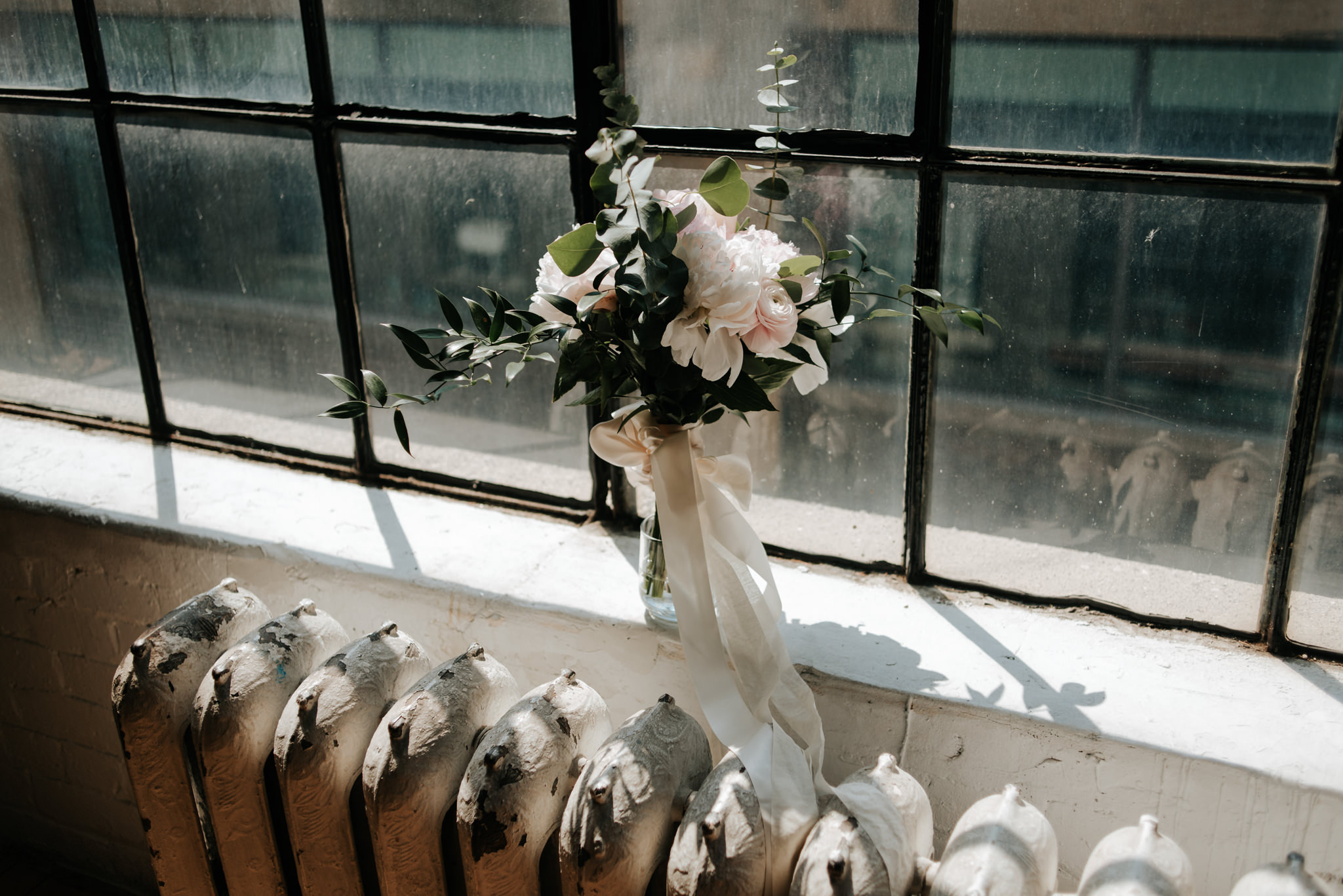 bouquet on window ledge in old loft at sunrise