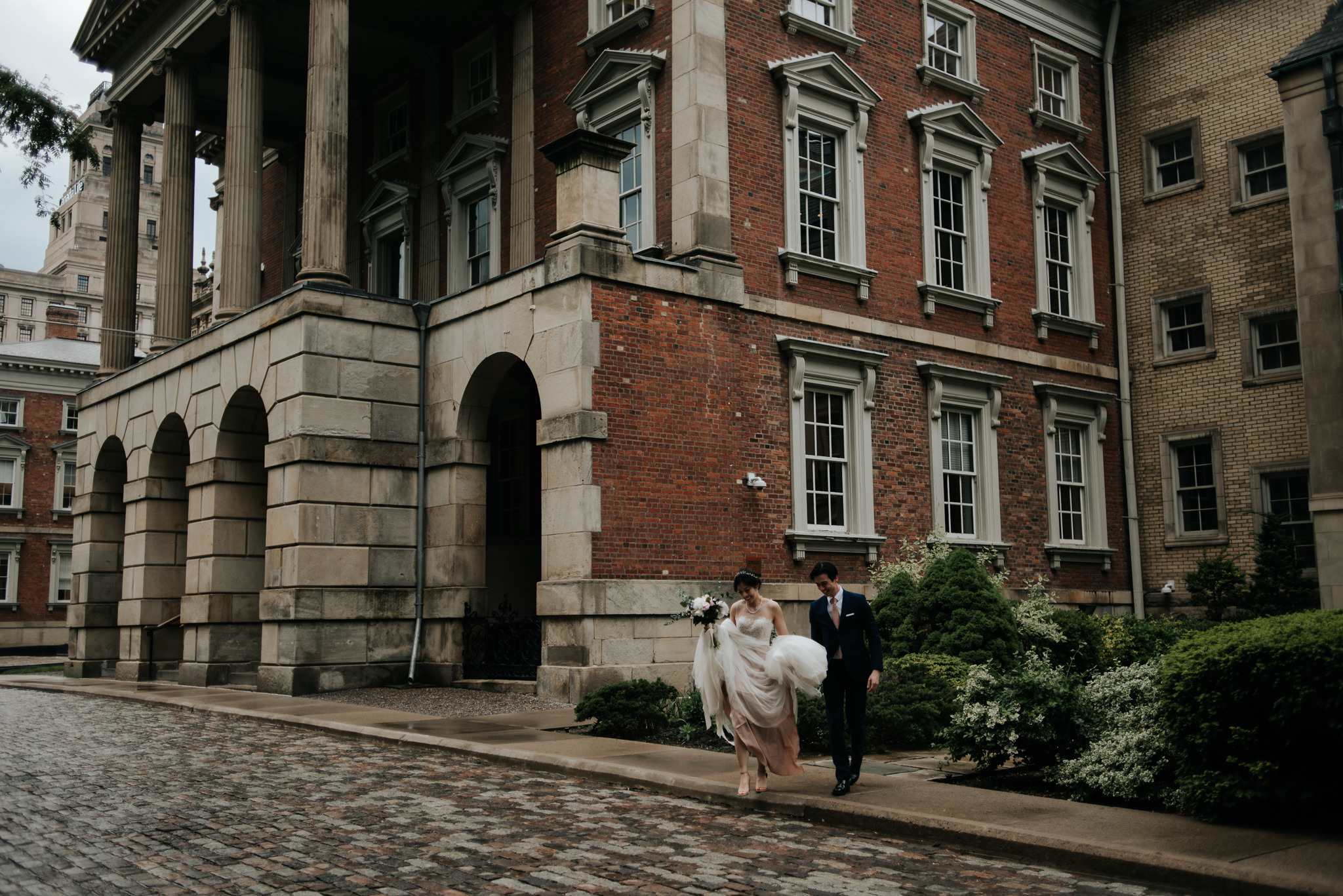 bride and groom walking on cobble stone street